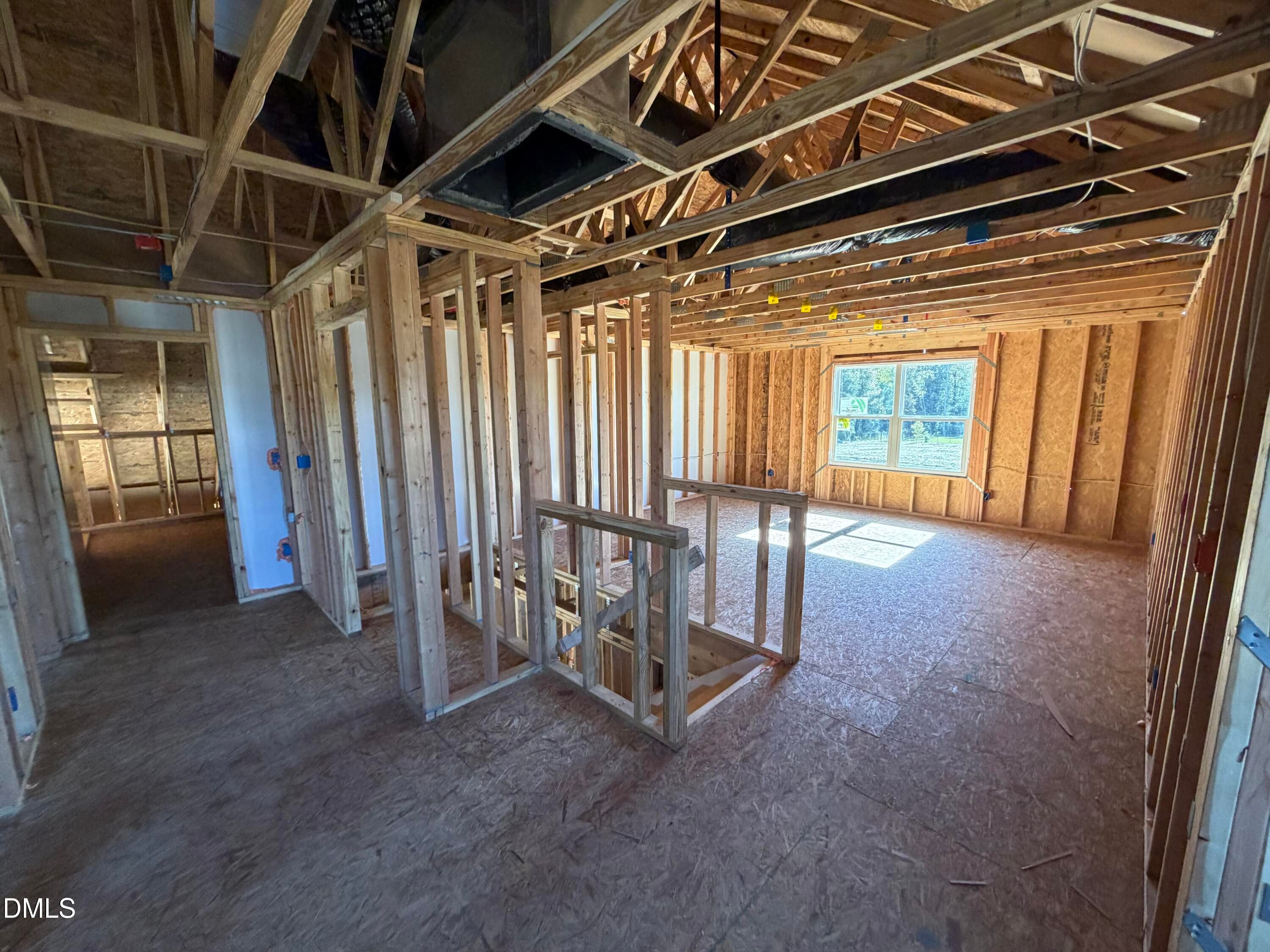 Exposed wooden framing in open two-story interior with staircase, large windows, and vaulted ceiling in Davidson Homes The Ash B, Lillington, NC