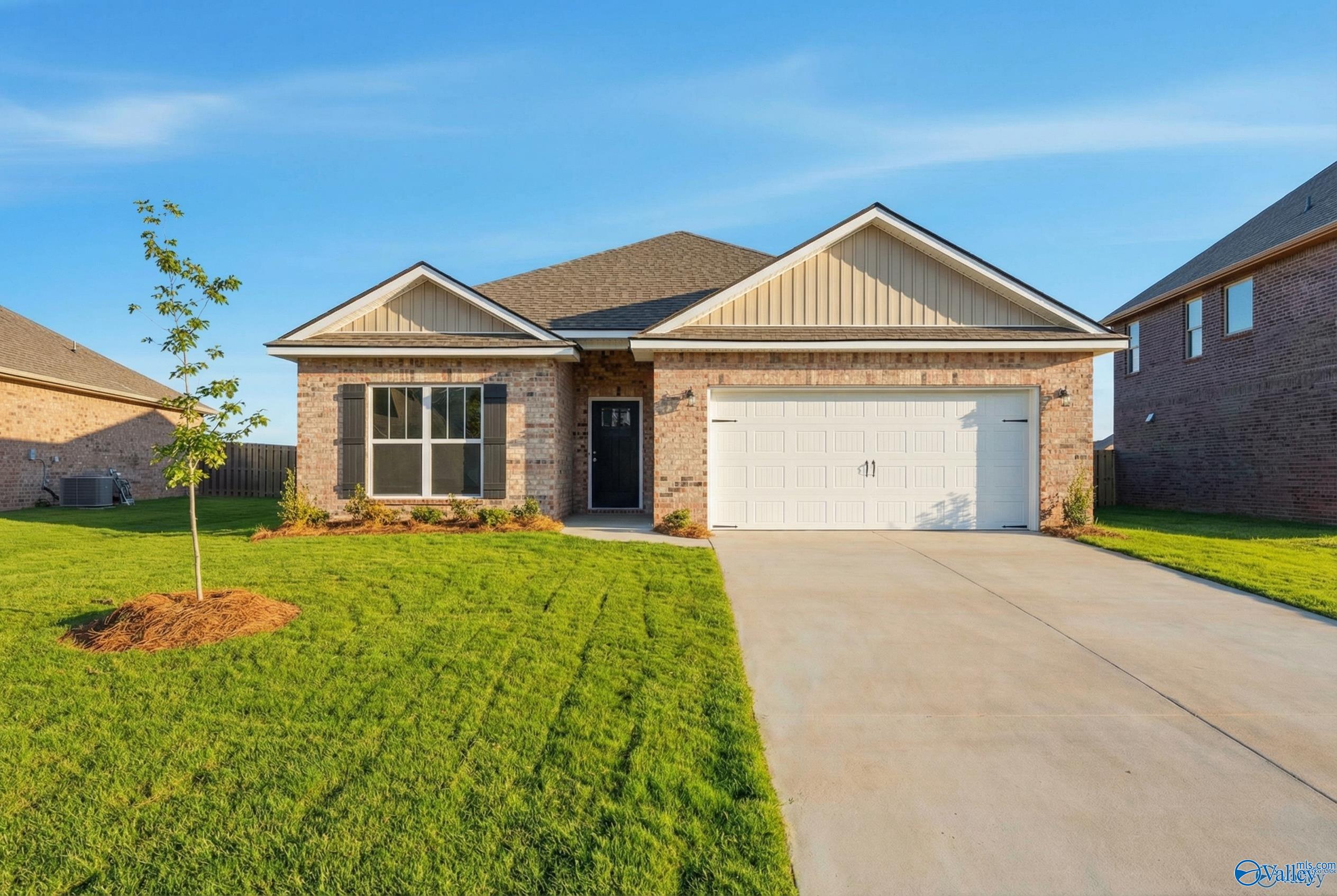 Modern single-story home exterior with brick accents, 2-car garage, and landscaped front yard in Creekside, Harvest, AL by Davidson Homes The Everett