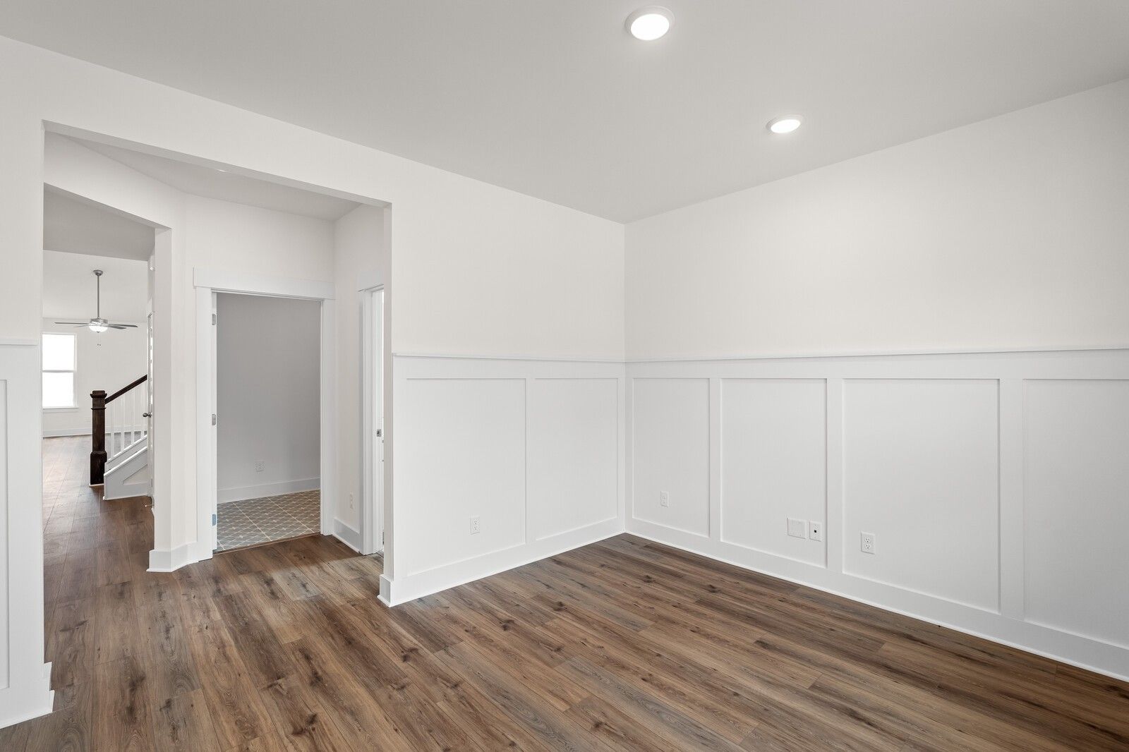 Spacious bedroom with white wainscoted walls, dark hardwood floors, en-suite door in Davidson Homes The Ridgeport, Gallatin, TN