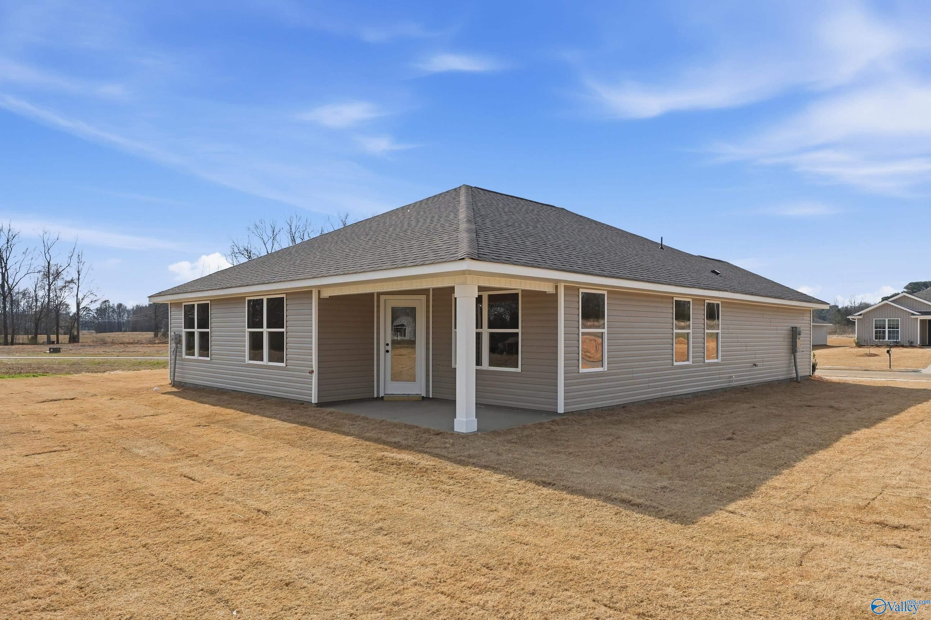 Single-story beige home with covered front porch, gabled roof, and large windows in Chapel Hill, Athens, Alabama