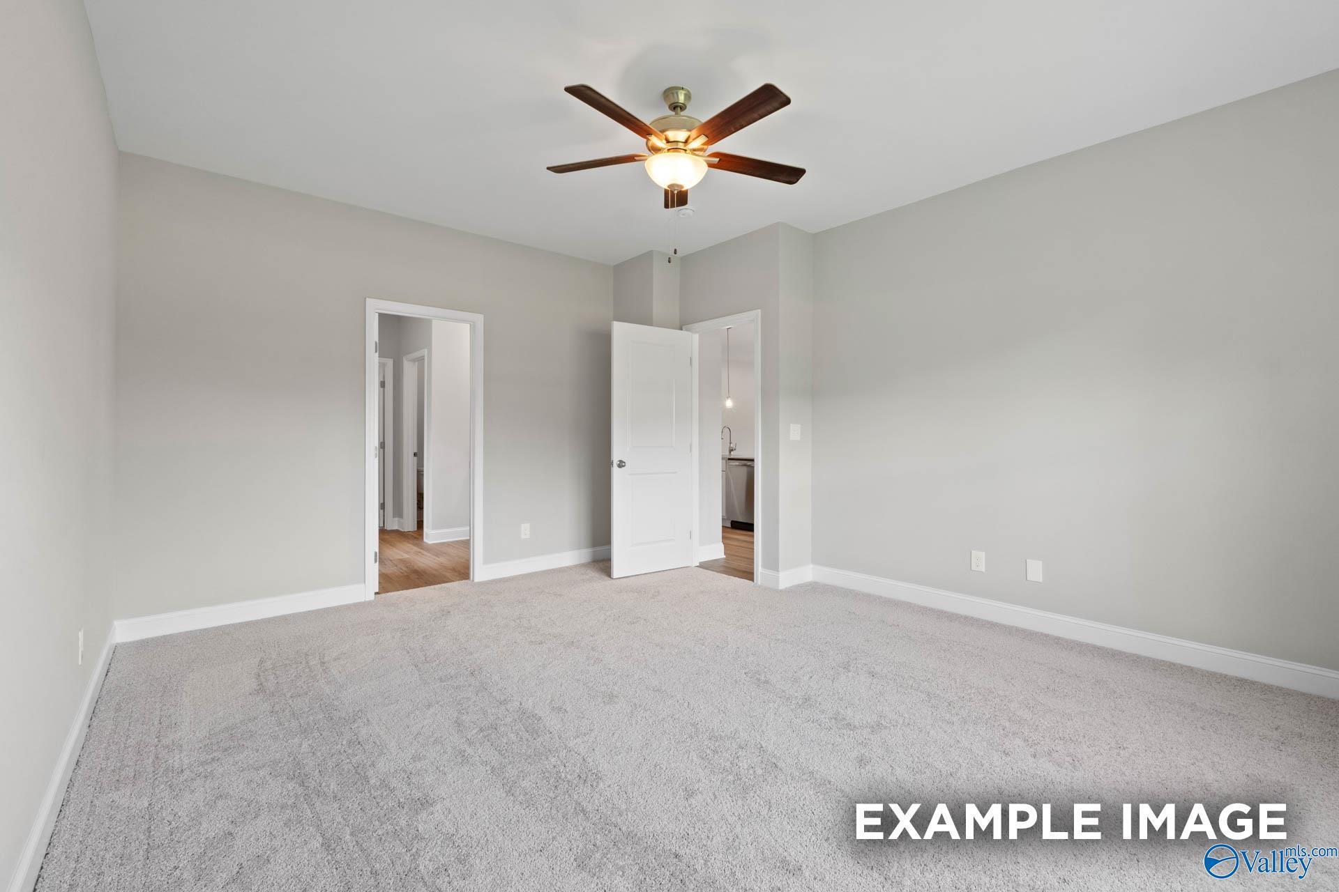 Spacious empty bedroom with gray walls, carpet flooring, and ceiling fan in Davidson Homes The Everett B, Athens, Alabama