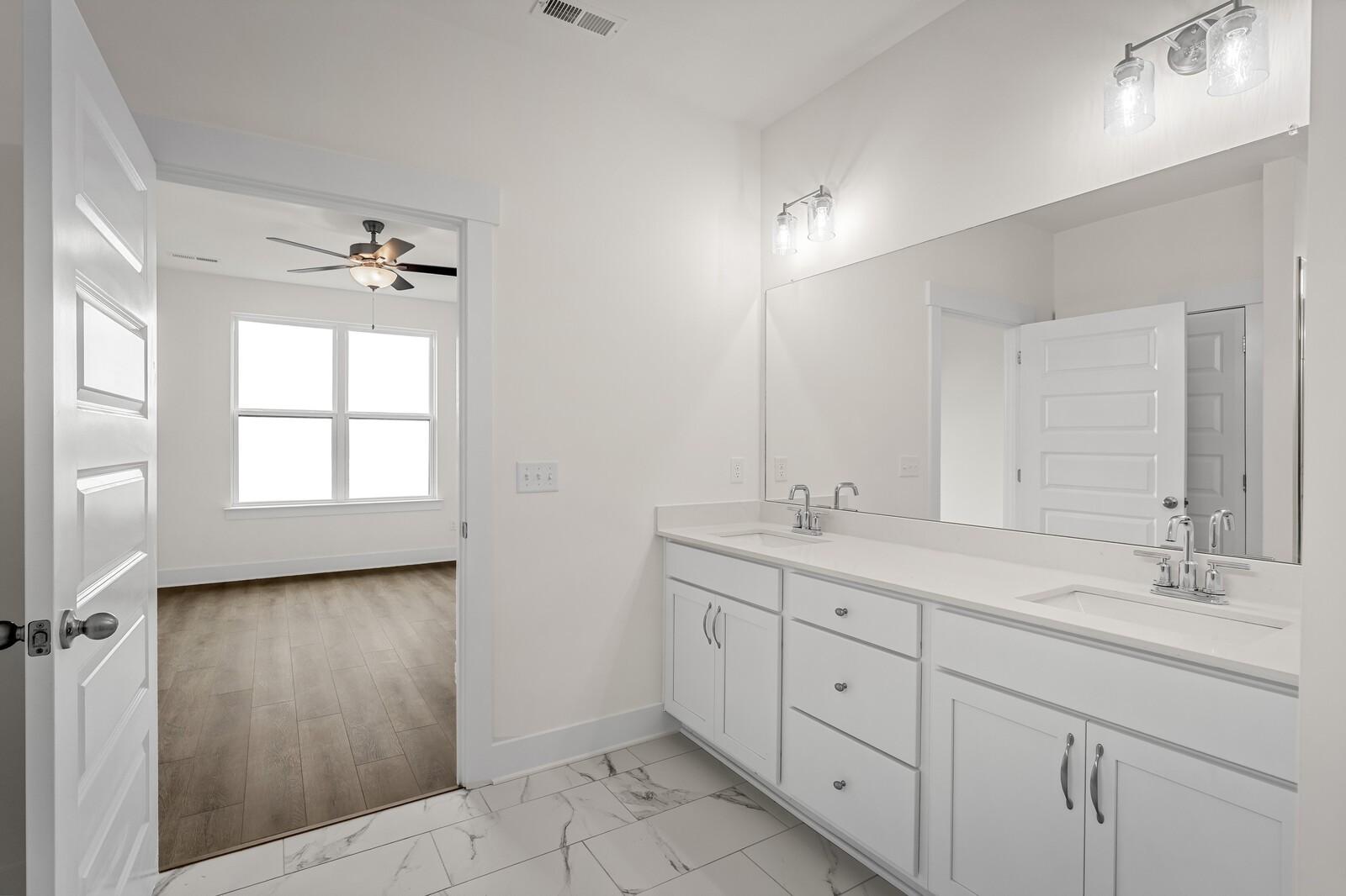 Modern double vanity bathroom with marble-style flooring in The Ridgeport D floor plan, Benders Cove, Mt. Juliet, TN.