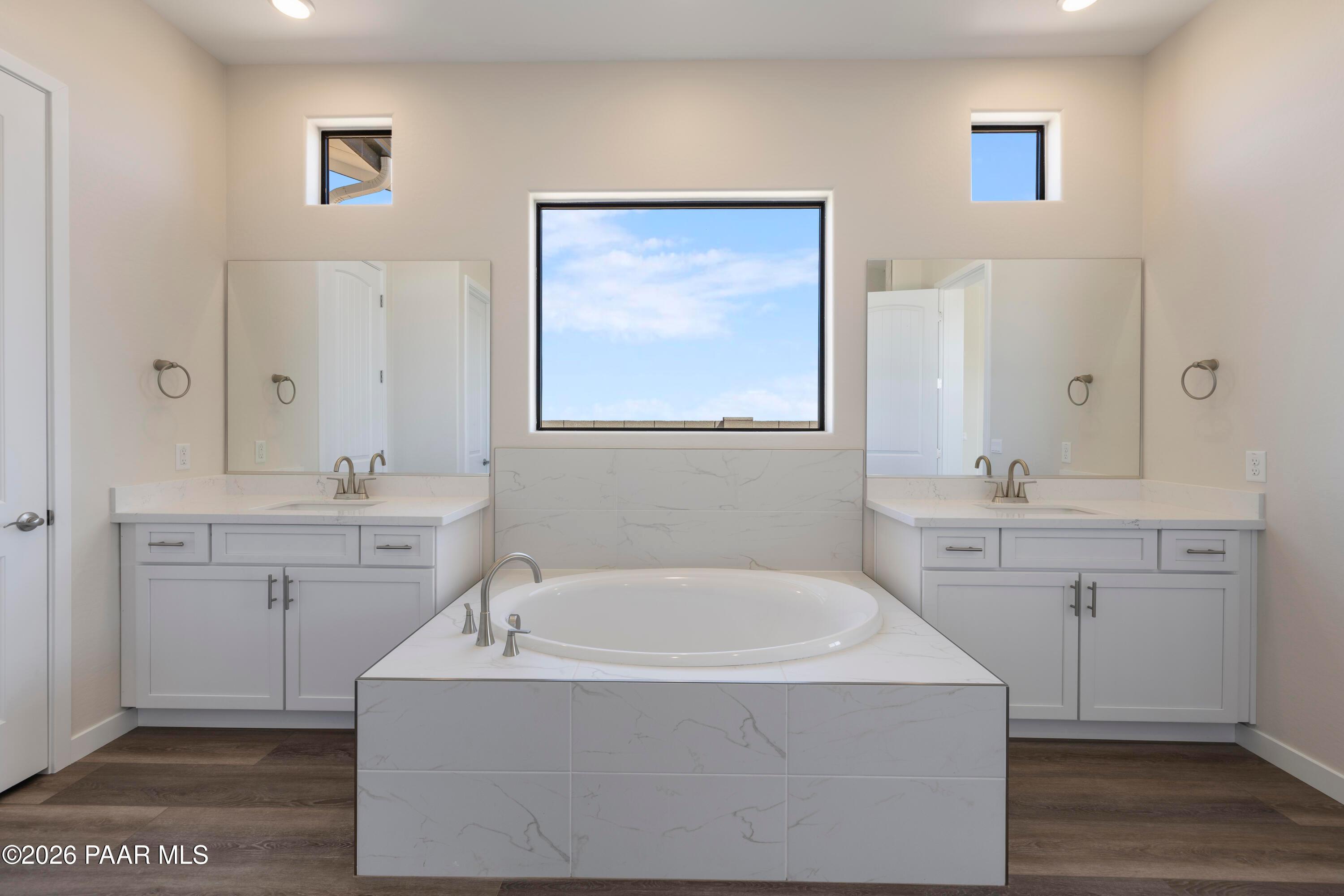 Elegant master bathroom with dual vanities, freestanding soaking tub, marble surround in Davidson Homes The Soleil E, Prescott, Arizona