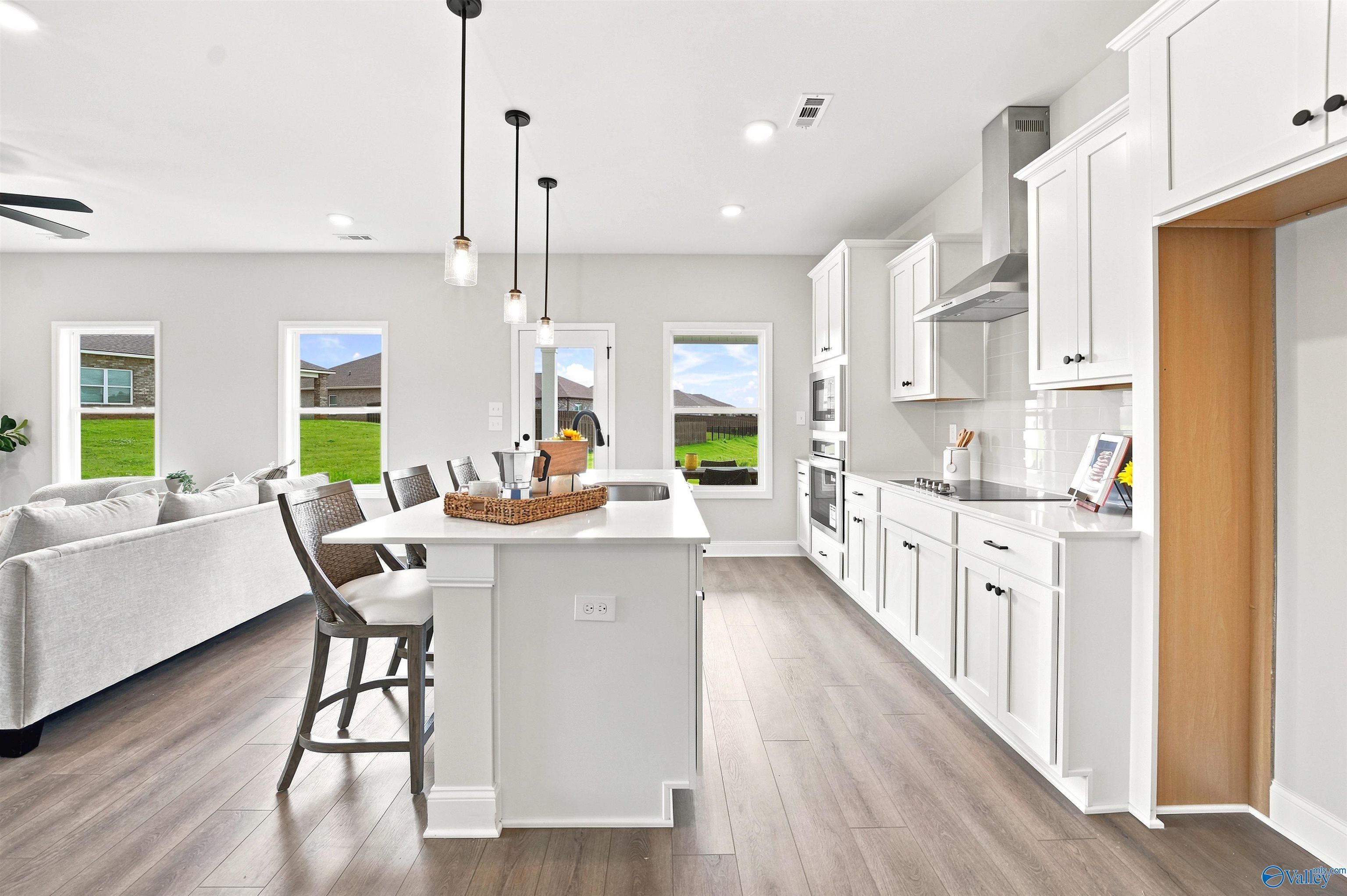 Modern white kitchen with island, pendant lighting, and open layout in The Burton B floor plan, Heritage Lakes, New Market.