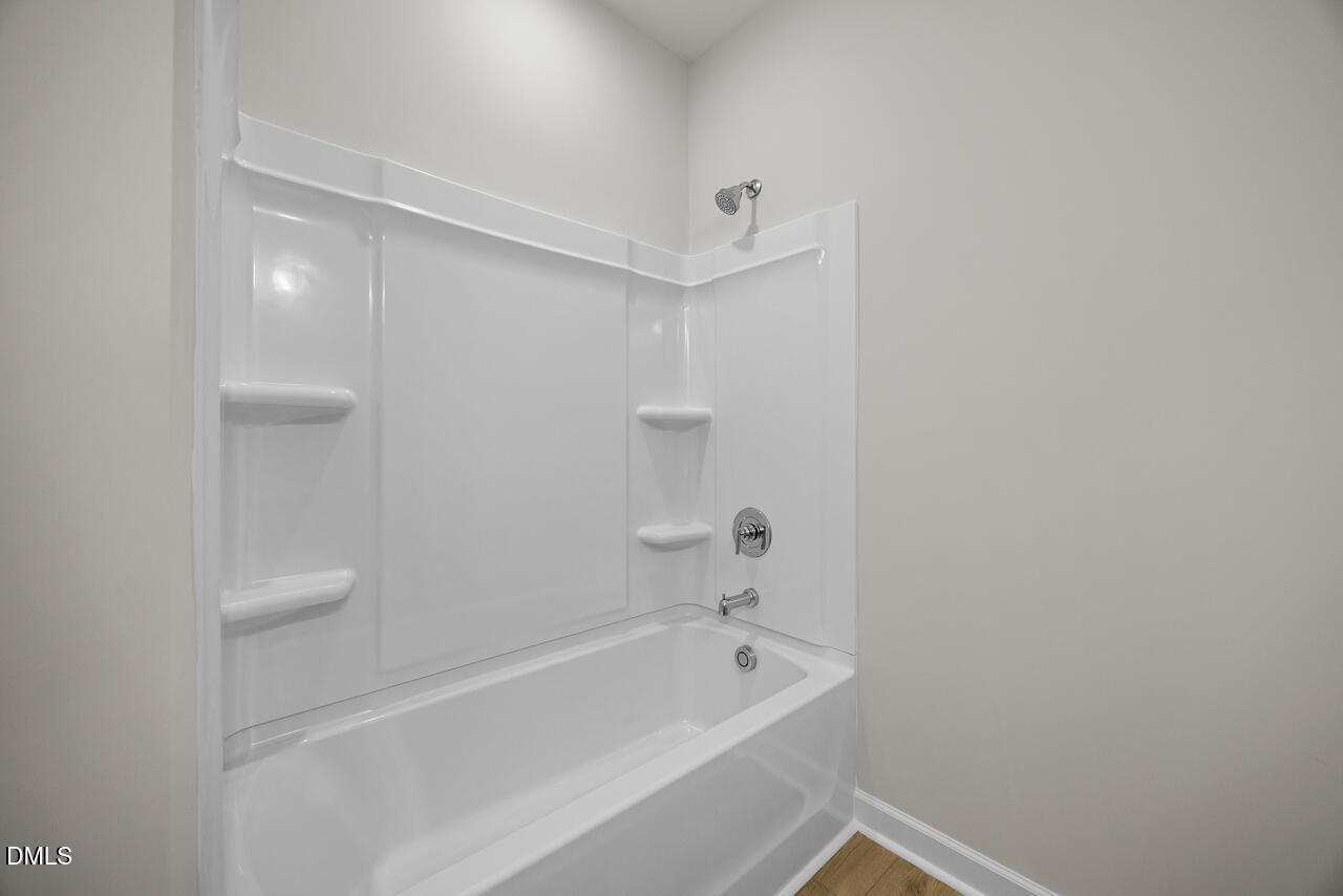 Modern white bathtub and shower combo in The Chestnut floor plan by Davidson Homes in Montrose, Aberdeen, North Carolina.