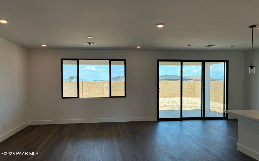 Spacious living room with large windows and sliding glass doors in The Durango II G at South Ranch, Prescott, Arizona.