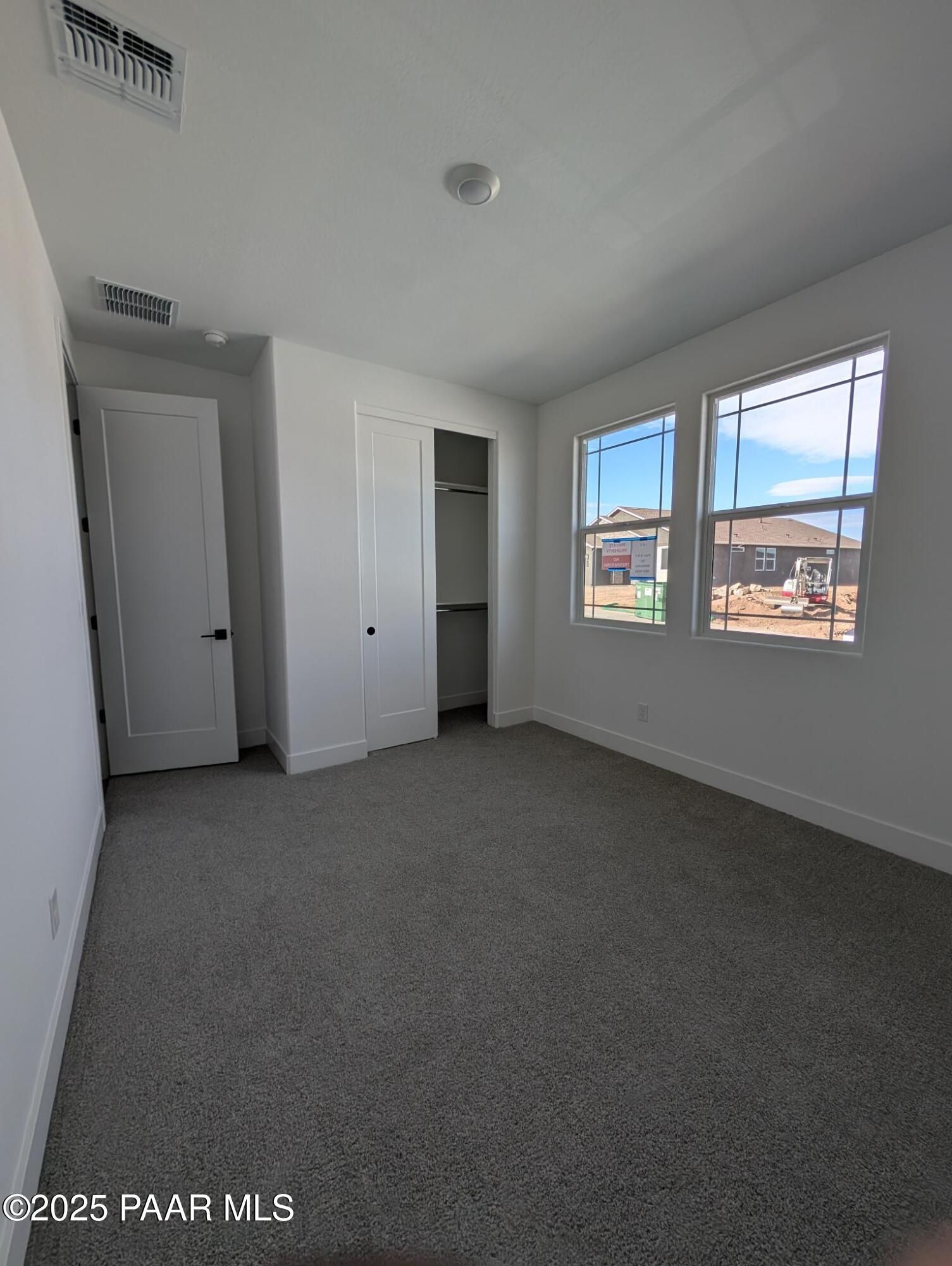 Bright bedroom with large dual windows, built-in closet, and carpet flooring in Davidson Homes The Sheridan II F, Prescott Arizona