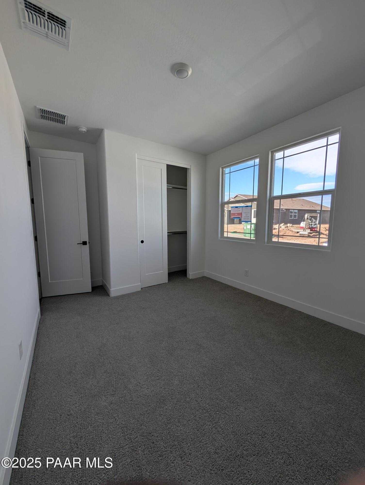 Bright bedroom with large dual windows, built-in closet, and carpet flooring in Davidson Homes The Sheridan II F, Prescott Arizona