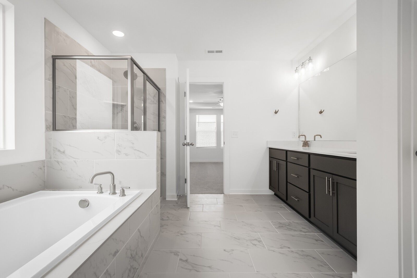 Modern master bathroom with freestanding tub, frameless glass shower, double vanity in Davidson Homes The Gordon C, White House, TN