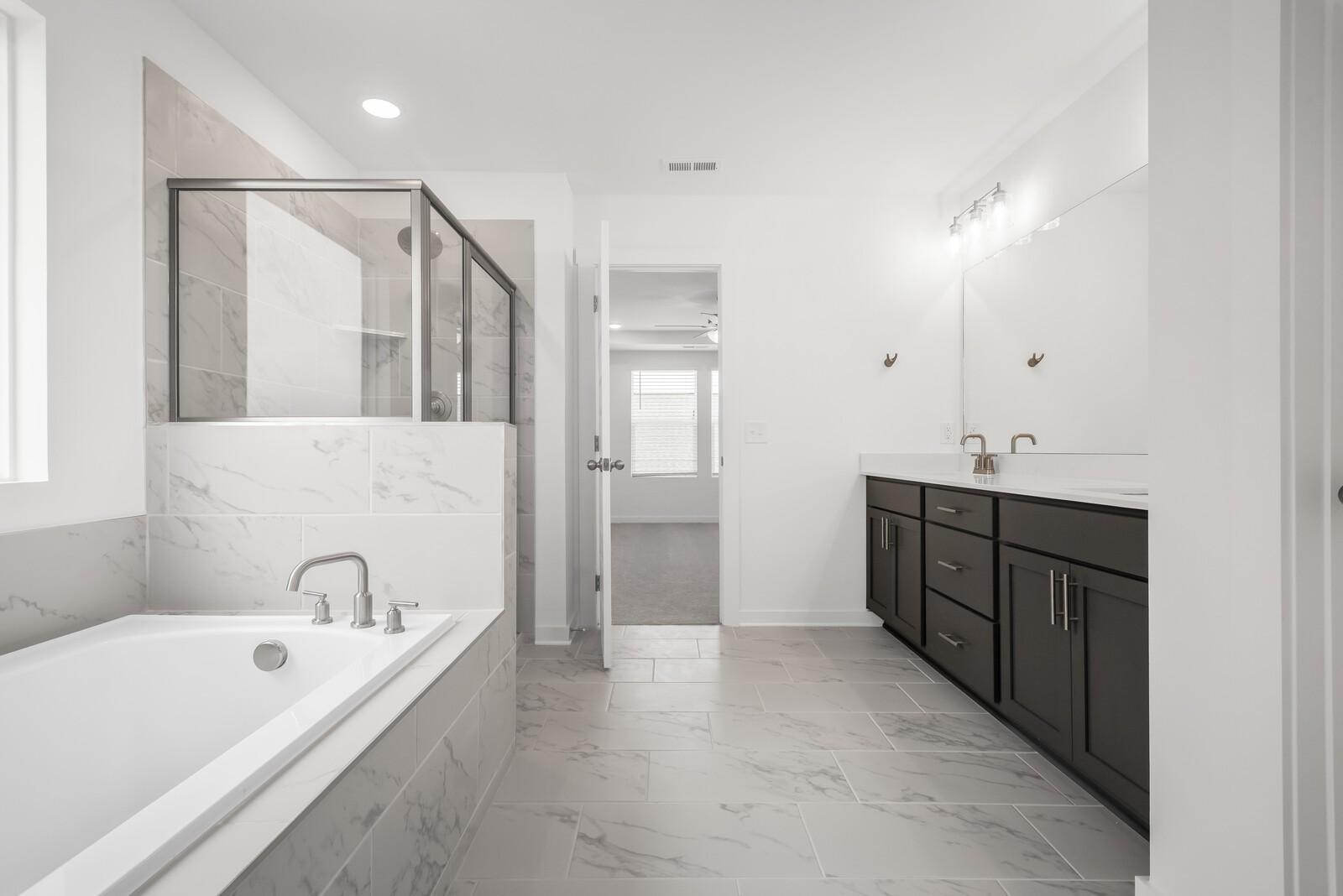 Modern master bathroom with freestanding tub, frameless glass shower, double vanity in Davidson Homes The Gordon C, White House, TN