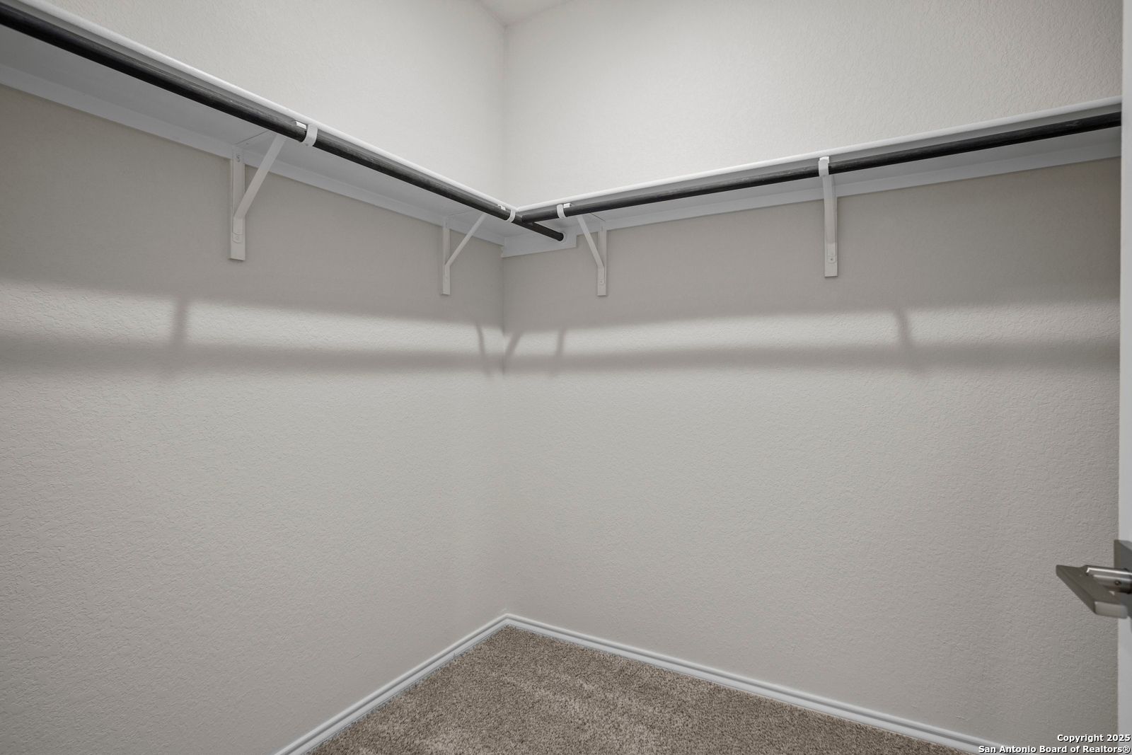 Spacious walk-in closet with built-in shelves and hanging rods in Davidson Homes The Asheville J, Comanche Ridge, San Antonio, Texas