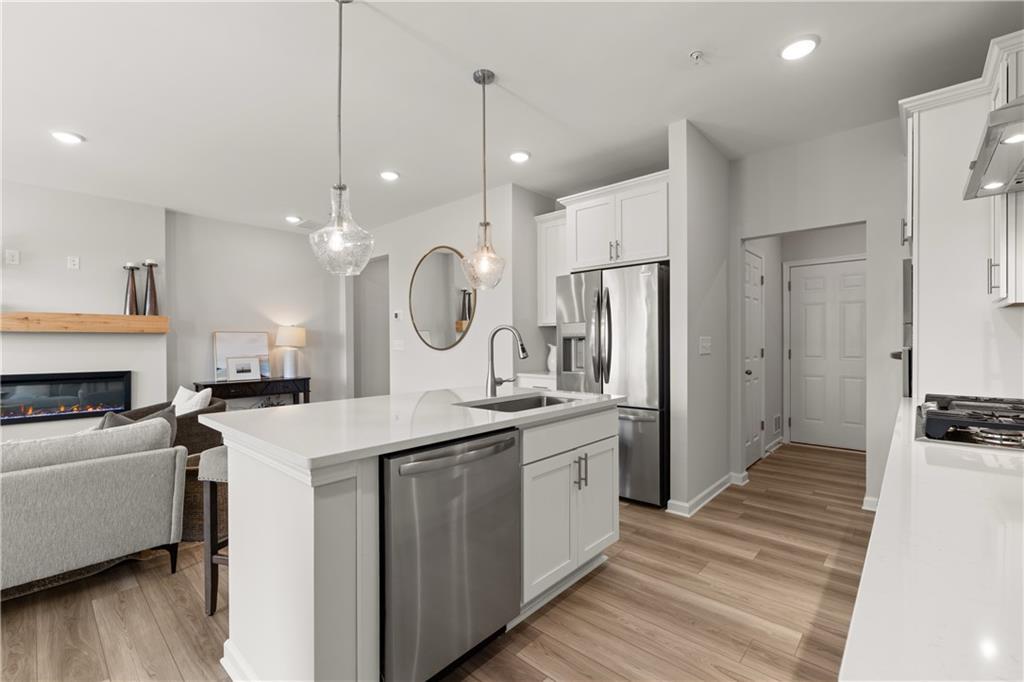 Modern open-concept kitchen with white cabinets and island in The Wake B floor plan at Hemingway in Cumming, Georgia.