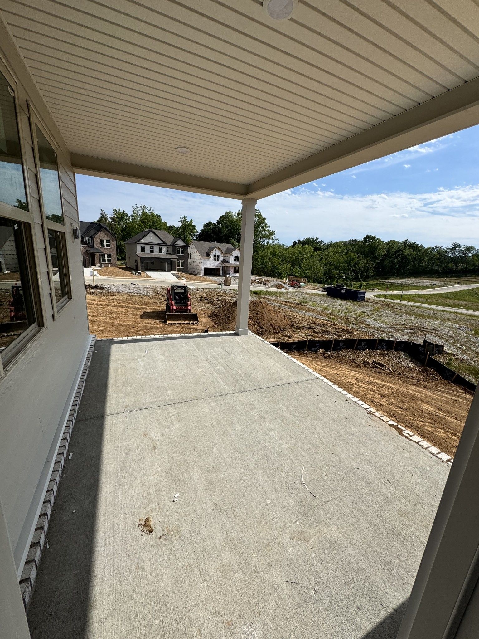 Covered front porch with concrete slab on new Davidson Homes Prairie C in Woods Crossing, Gallatin, TN construction site