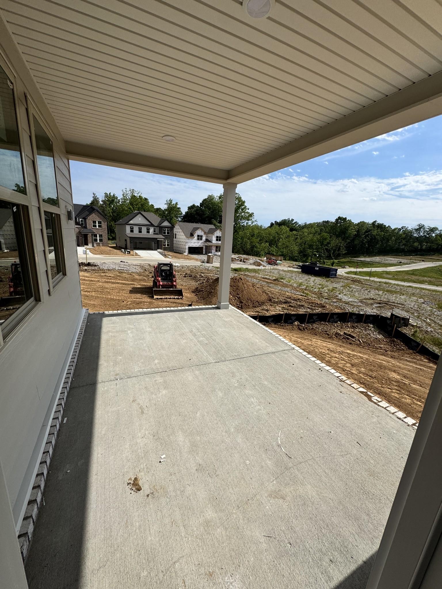 Covered front porch with concrete slab on new Davidson Homes Prairie C in Woods Crossing, Gallatin, TN construction site
