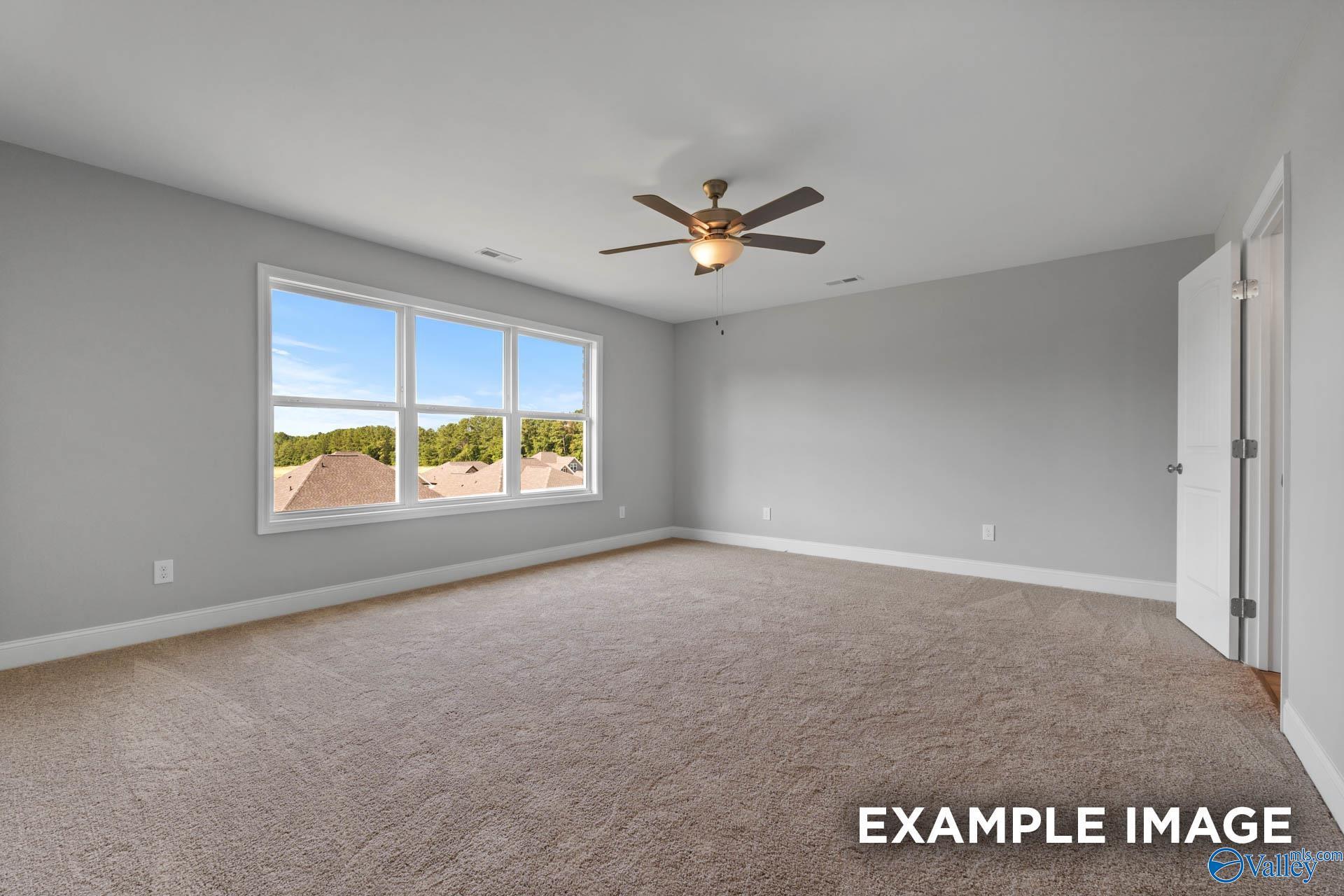 Bright empty bedroom with large windows overlooking trees, ceiling fan, in Davidson Homes The Shelby B, New Market, Alabama