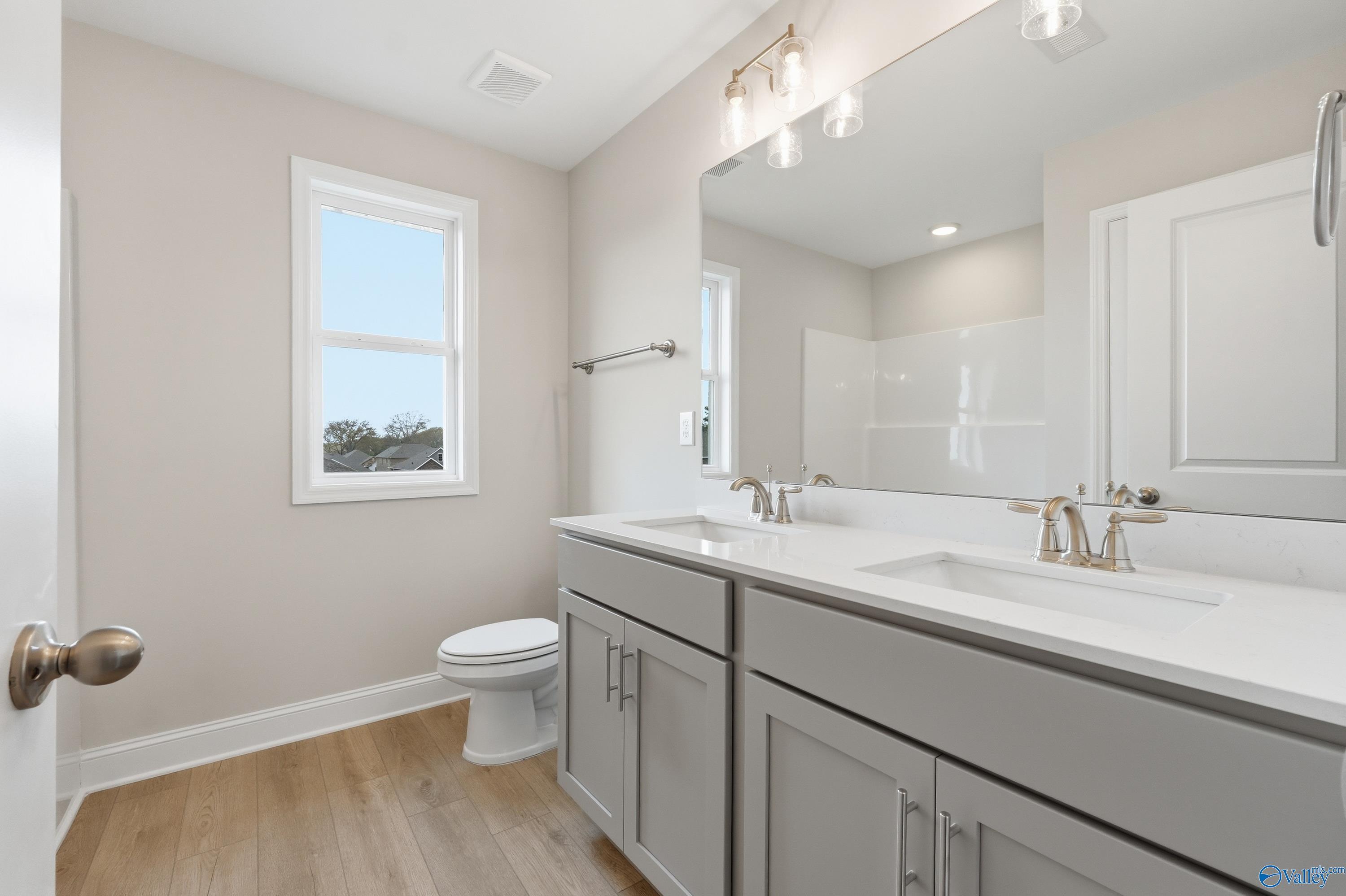 Modern double-sink vanity with gray shaker cabinets and quartz countertop in Davidson Homes The Shelby B bathroom, New Market, AL