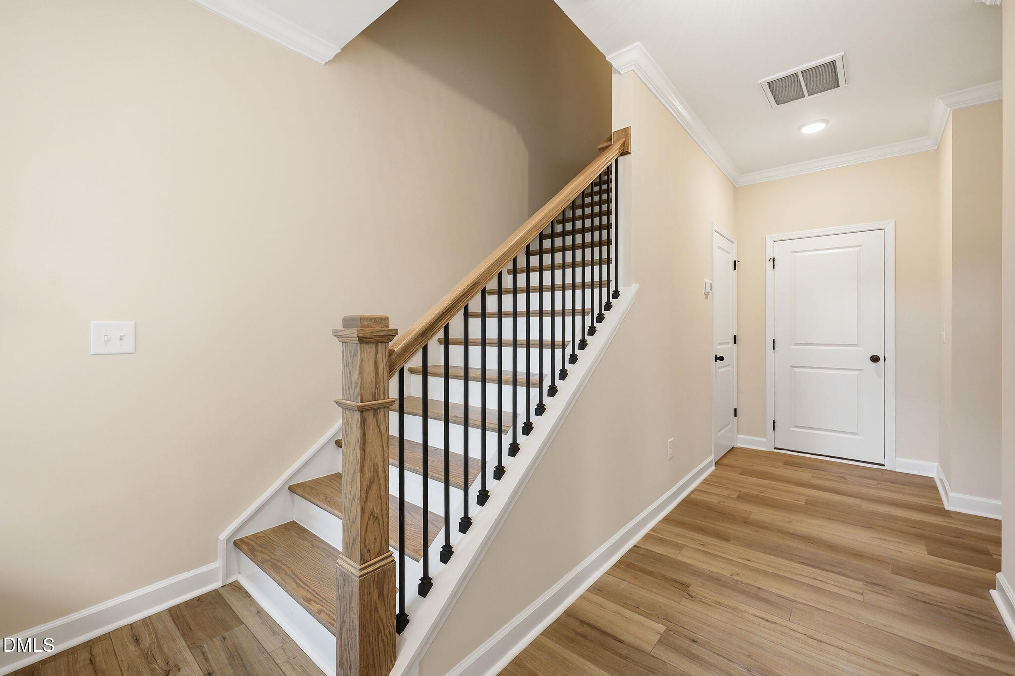 Staircase with wood treads and black iron balusters in The Mitchell floor plan by Davidson Homes in Camden Park, NC.