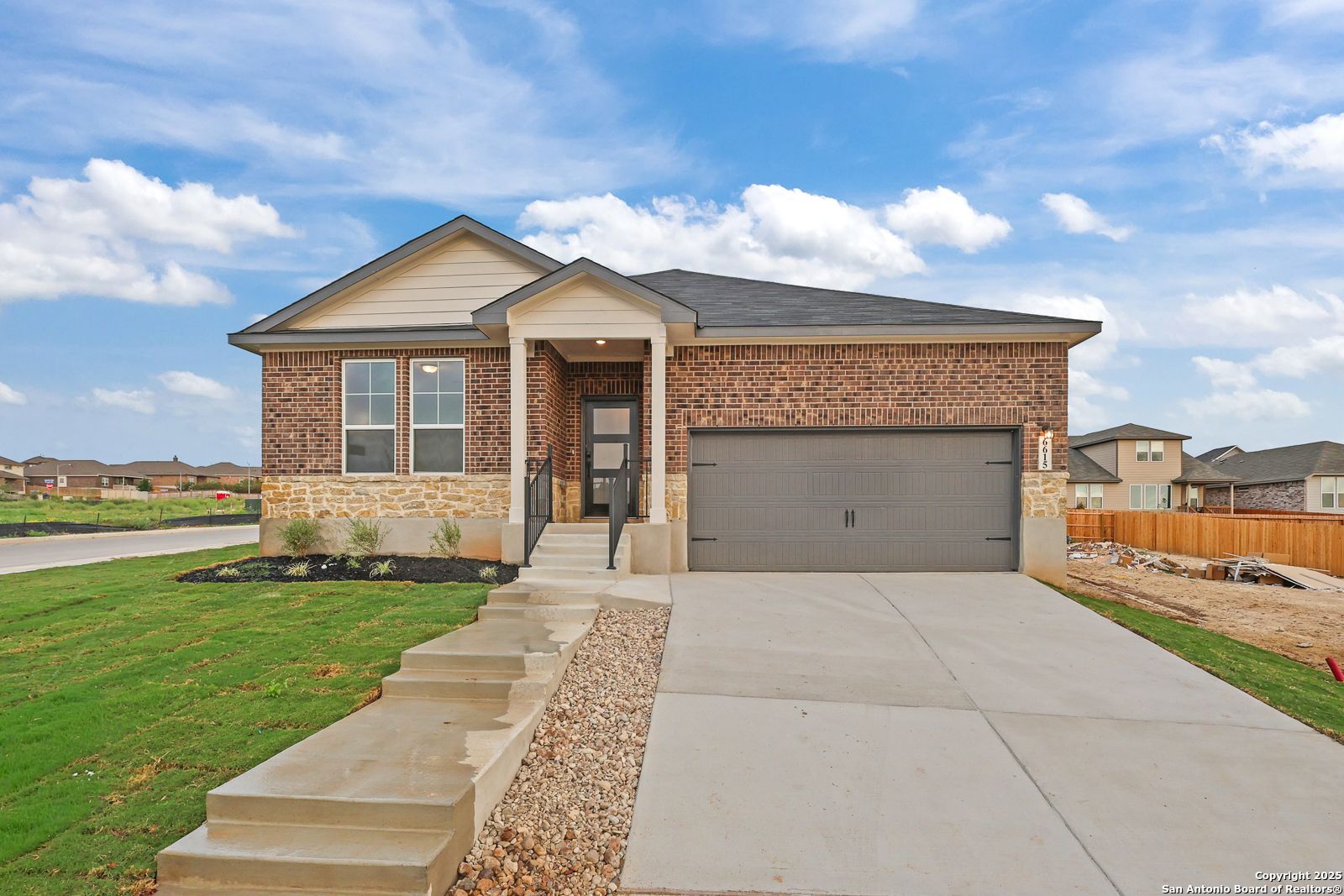 Modern 1-story brick home with 2-car garage, covered entry, and landscaped yard in Comanche Ridge, San Antonio, Texas - Davidson Homes The Daphne K