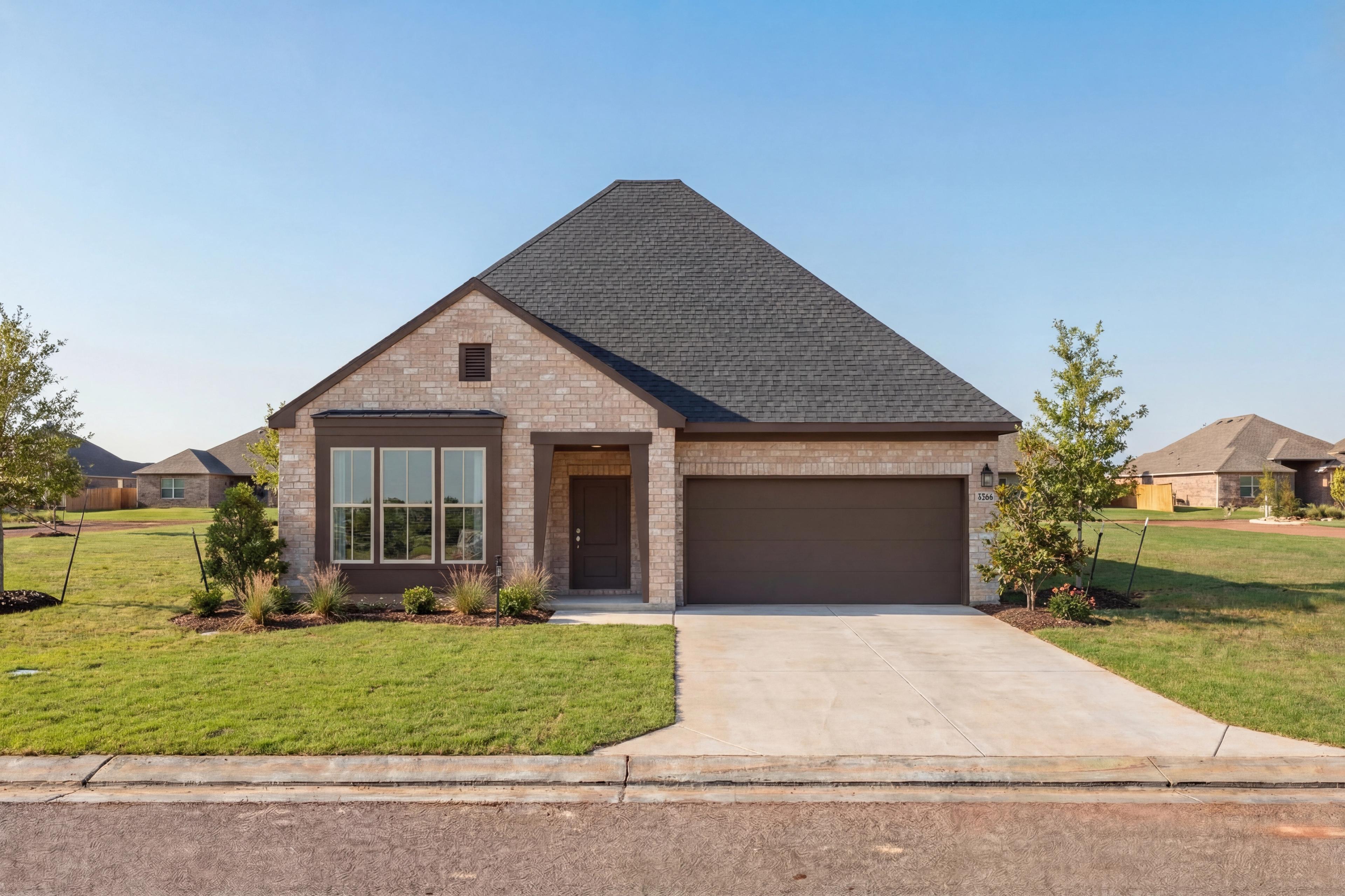 Modern single-story brick exterior of The Glen C home design with steep gabled roof, two-car garage, and landscaped front yard in Josephine, Texas