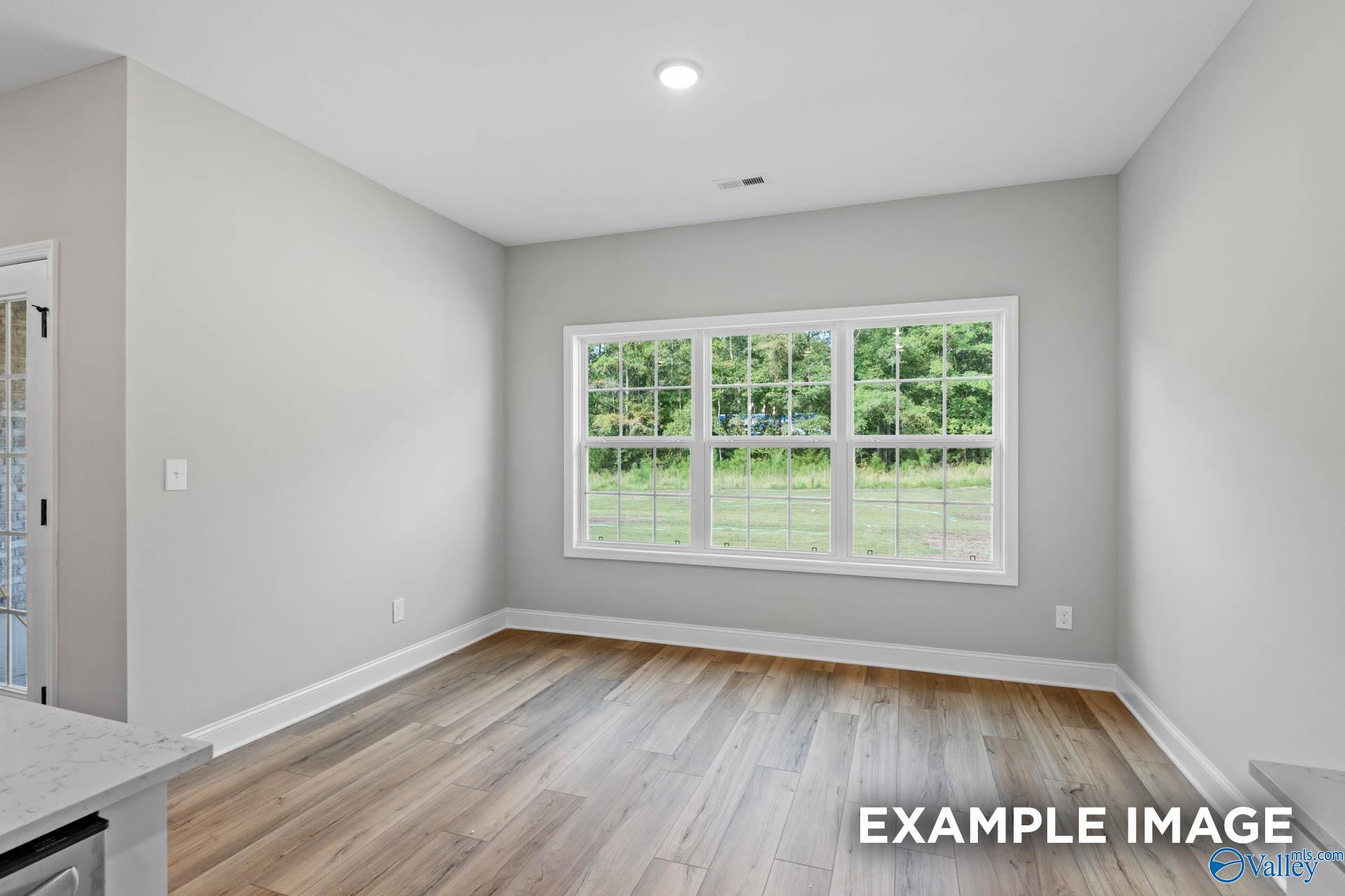 Bright, open-concept dining area with wood-look flooring in The Montgomery B floor plan by Davidson Homes, Decatur, AL.