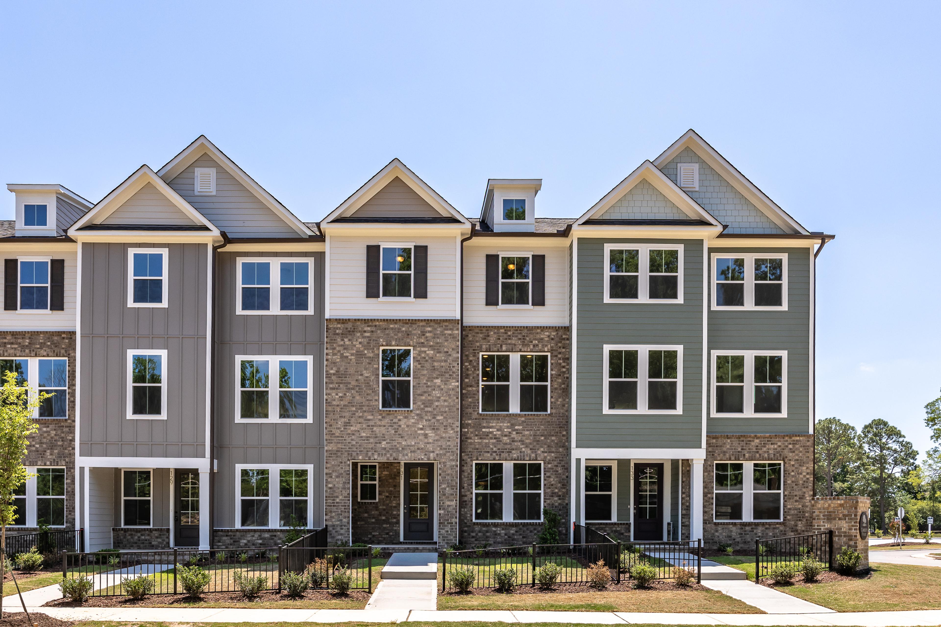 Three-story townhome exteriors at Forestville Yard in Knightdale, NC, featuring brick, siding, and modern architecture.