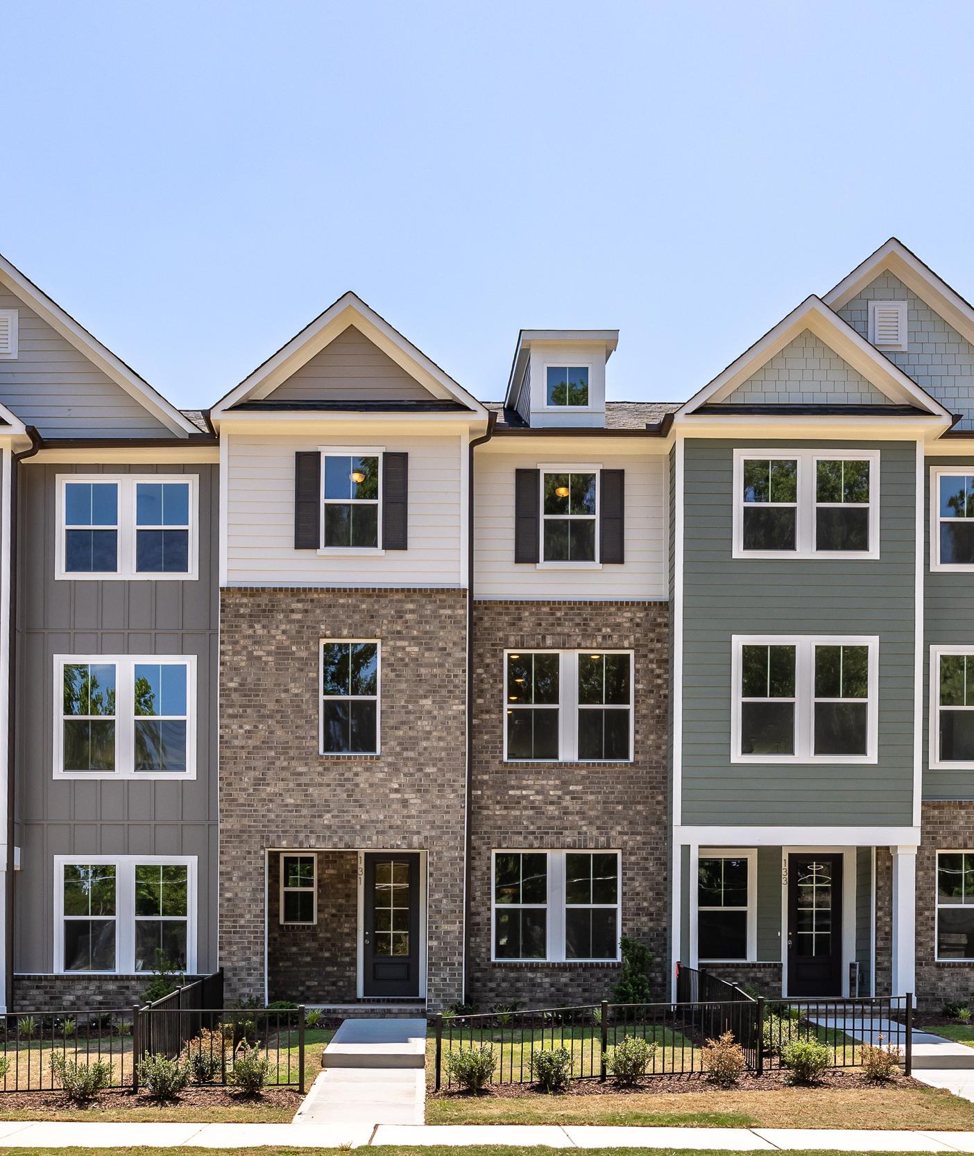Three-story townhome exteriors at Forestville Yard in Knightdale, NC, featuring brick, siding, and modern architecture.