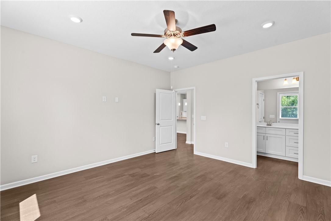 Spacious master bedroom with ceiling fan, hardwood floors, and en-suite bath double vanity in Evermore Homes The Orion, Cusseta, Alabama
