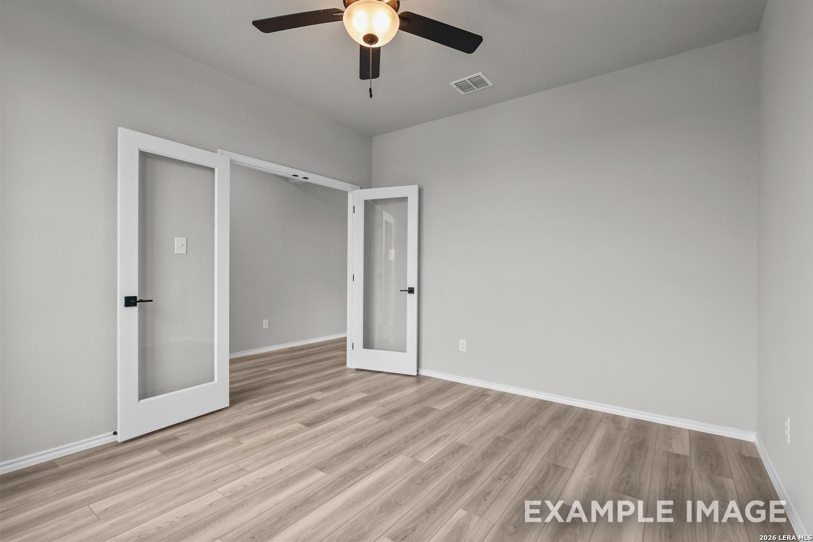 Modern home office with French doors and wood-look flooring in The Glenwood E floor plan by Davidson Homes, San Antonio.