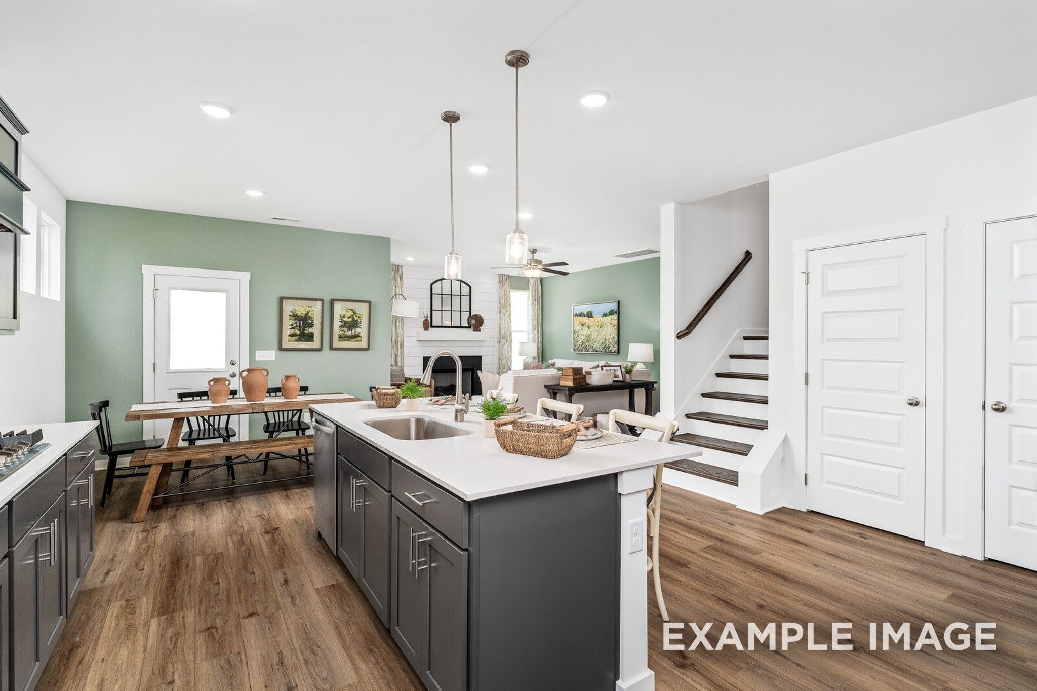 Open-concept kitchen with large island and dining area in The Ash A floor plan at Woods Crossing, Gallatin, Tennessee.