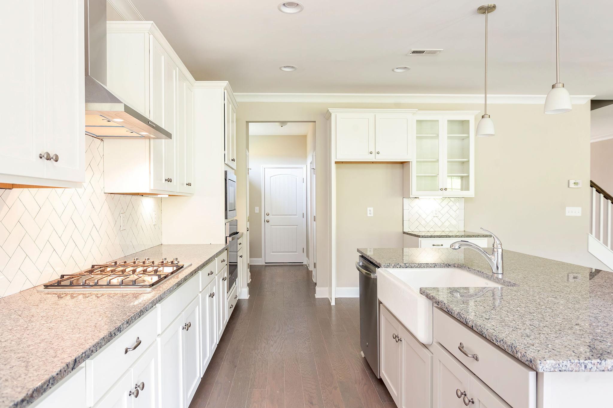Davidson Homes The Emory Floor Plan Kitchen with grey granite countertops, white cabinets, and appliances