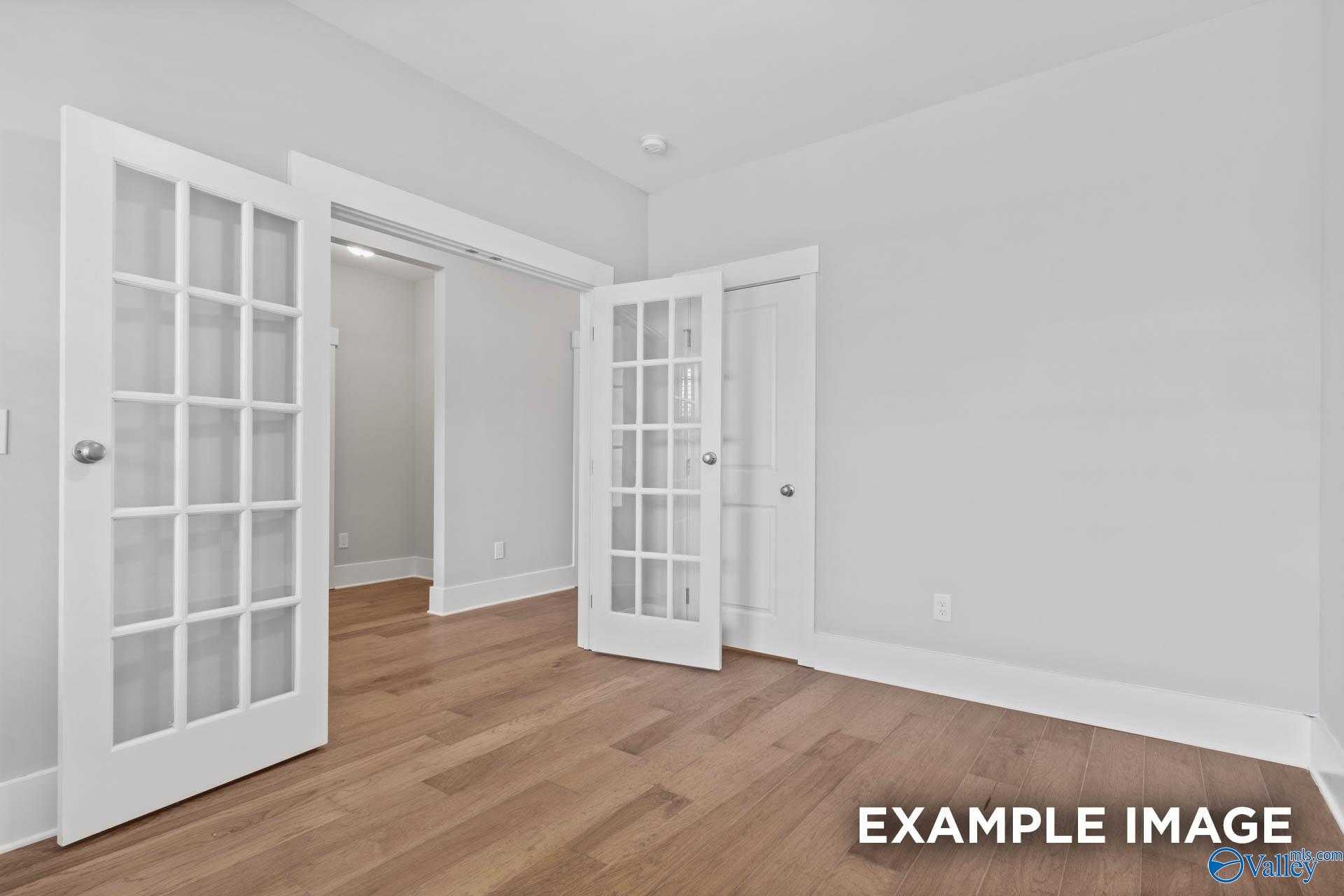 Open French doors with glass panels and hardwood floors in The Rockford 3-bedroom home by Davidson Homes, Meridianville, Alabama