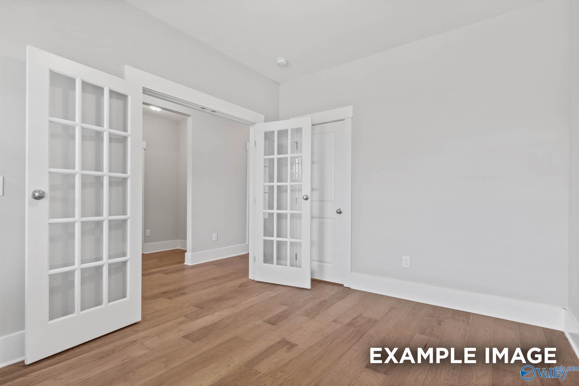 Open French doors with glass panels in bright entryway, hardwood floors, Davidson Homes The Rockford in Athens, AL