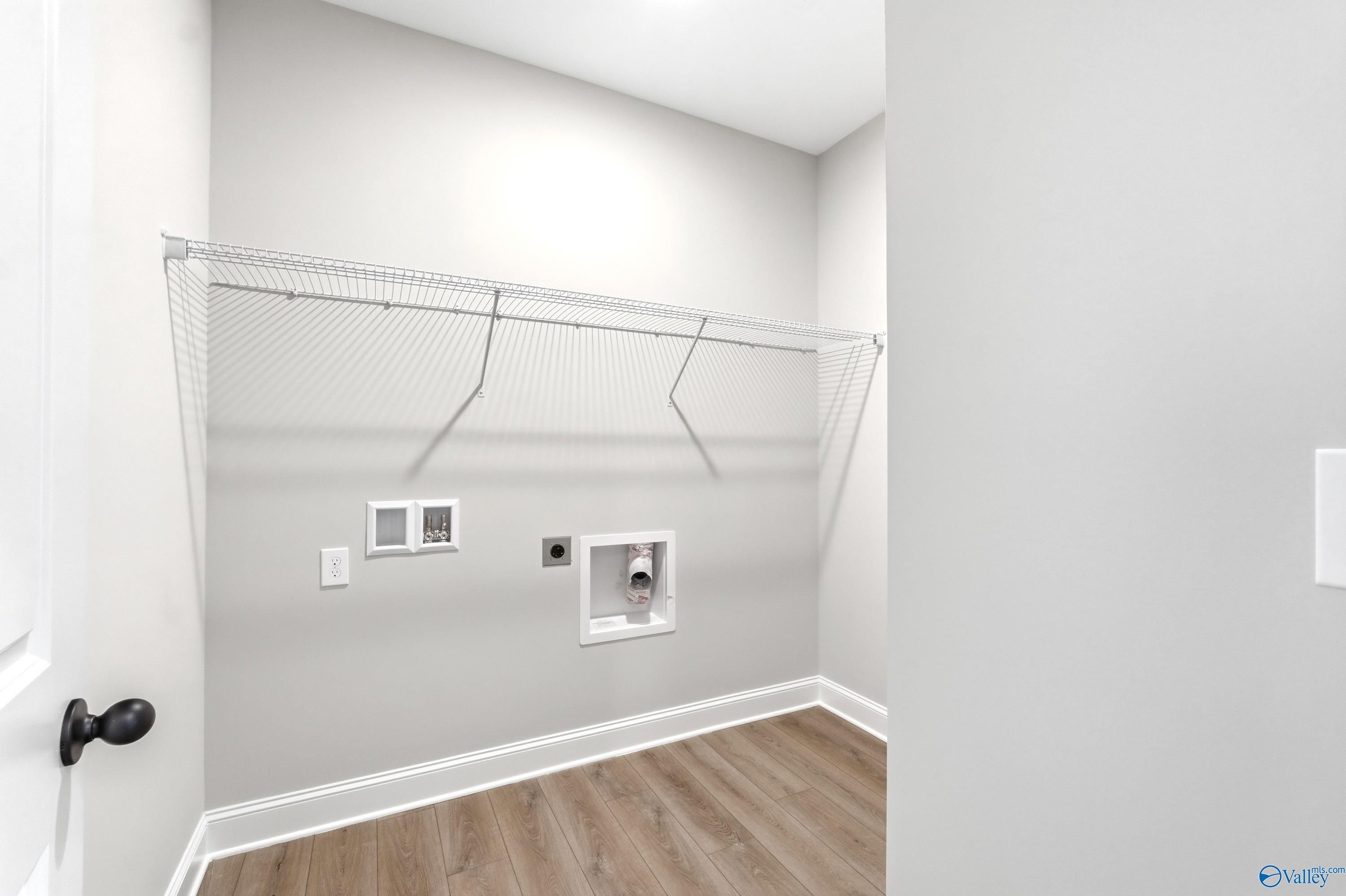 Laundry room with wire shelving and utility hookups in The Daphne C floor plan at Flint Meadows, New Market, Alabama.