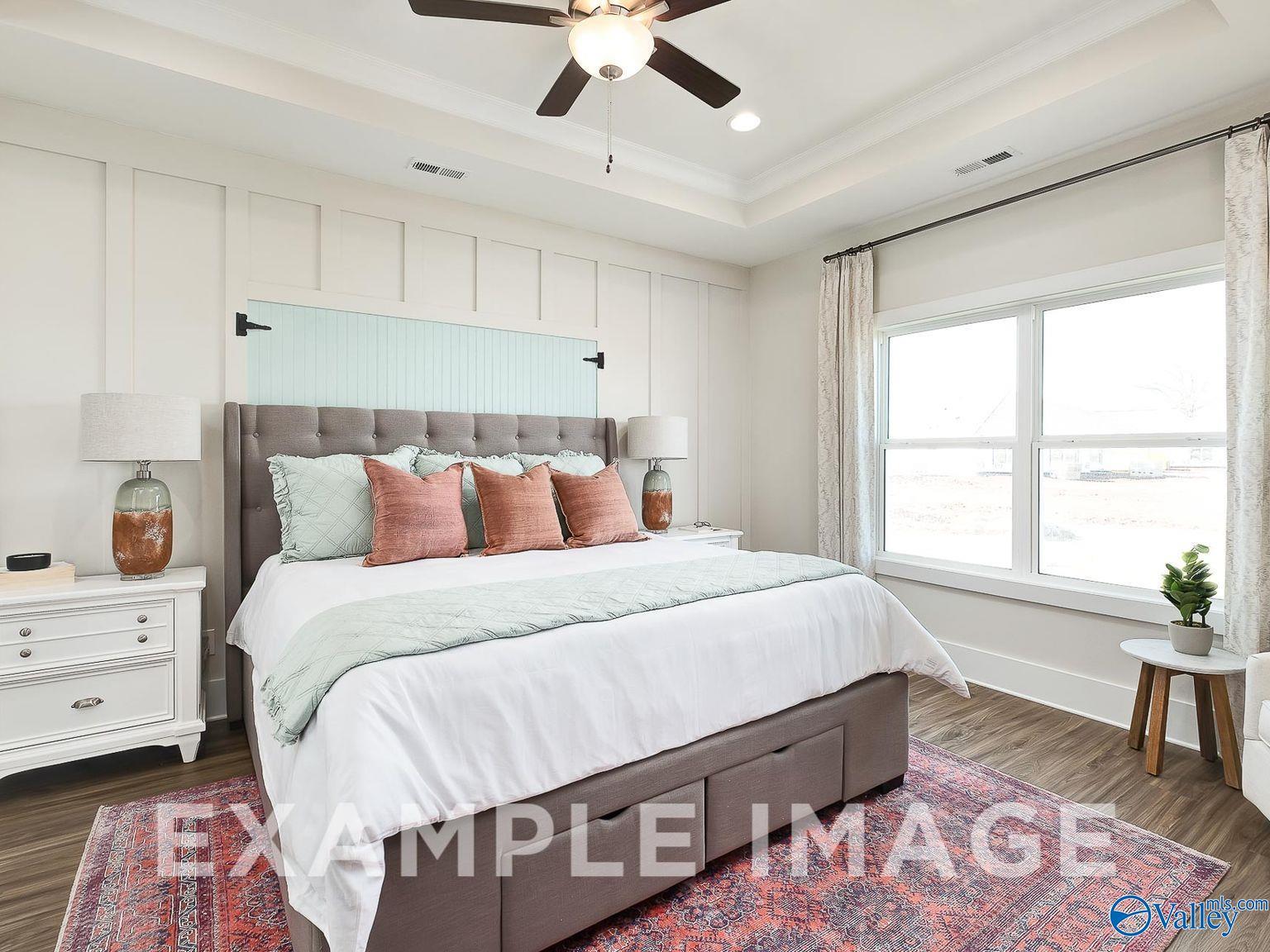 Luxurious master bedroom with tray ceiling, ceiling fan, and large windows in Davidson Homes The Everett B, Ivy Hills, Toney, Alabama