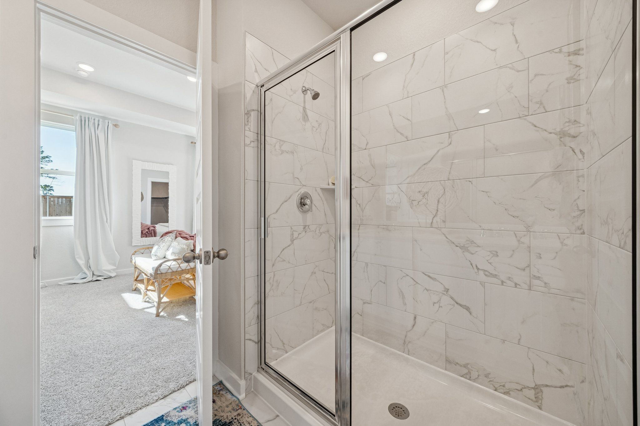 Modern master bathroom with frameless glass shower and white subway tiles at Spring Branch Crossing in Conroe Texas