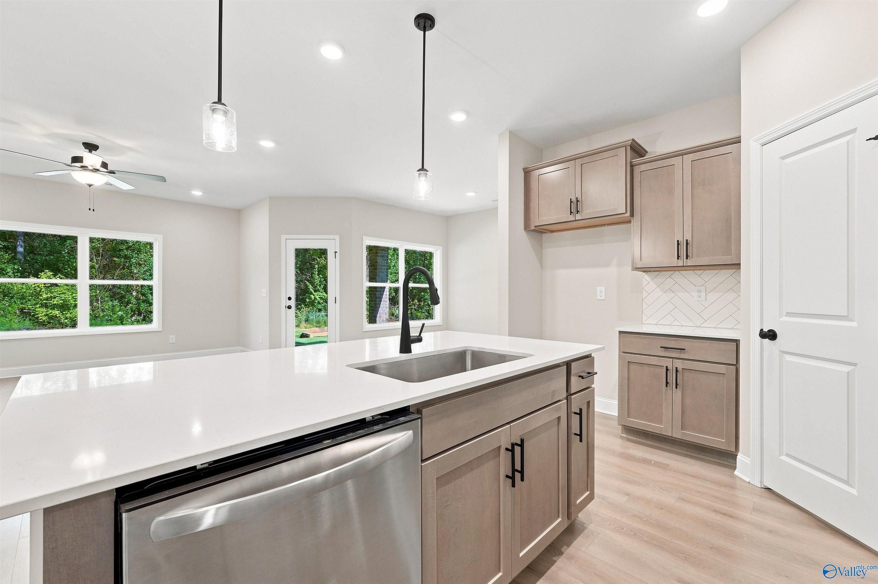 Modern kitchen with quartz island, stainless appliances, and pendant lighting in The Daphne home at Spragins Cove, Huntsville.