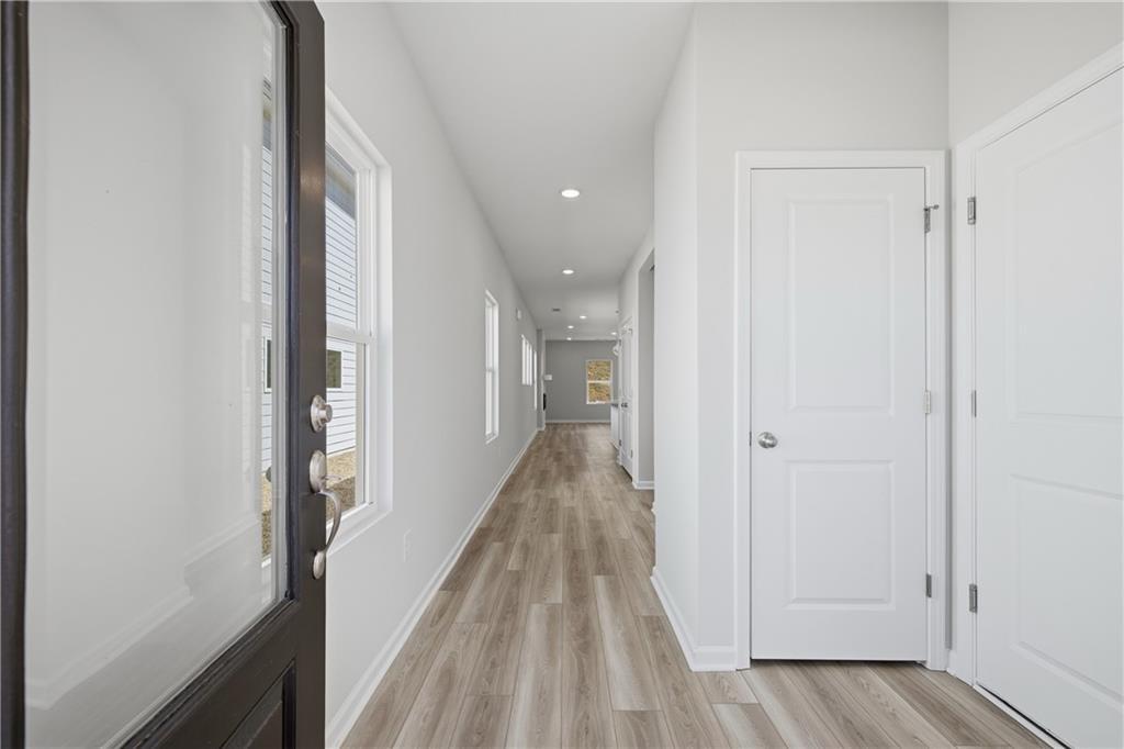 Bright entry foyer with luxury vinyl plank flooring and white doors in Davidson Homes' The Oconee B, The Bluffs, Canton, GA