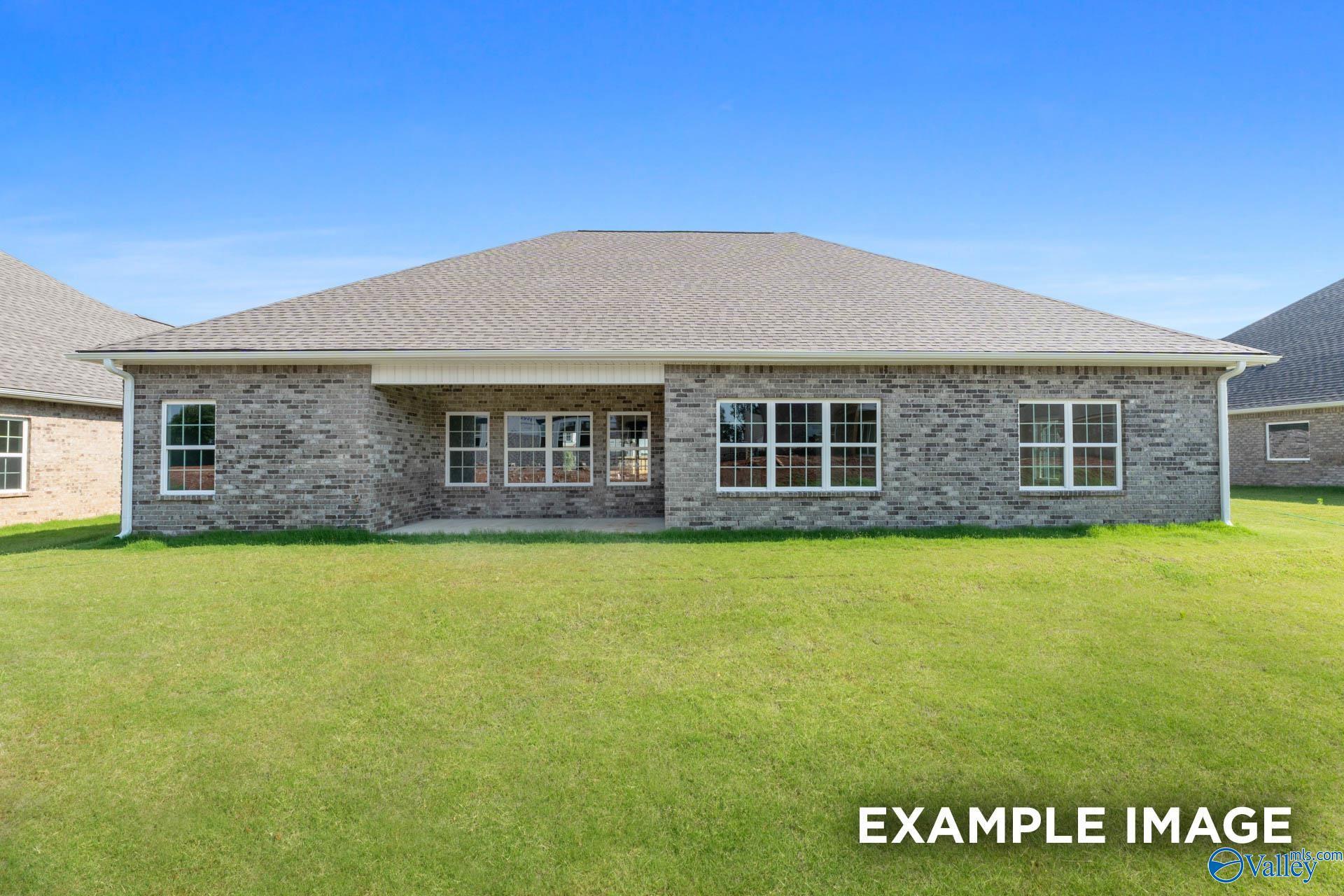 Brick single-story home exterior with covered patio, large windows, and green lawn in Riverton Preserve, Huntsville, Alabama