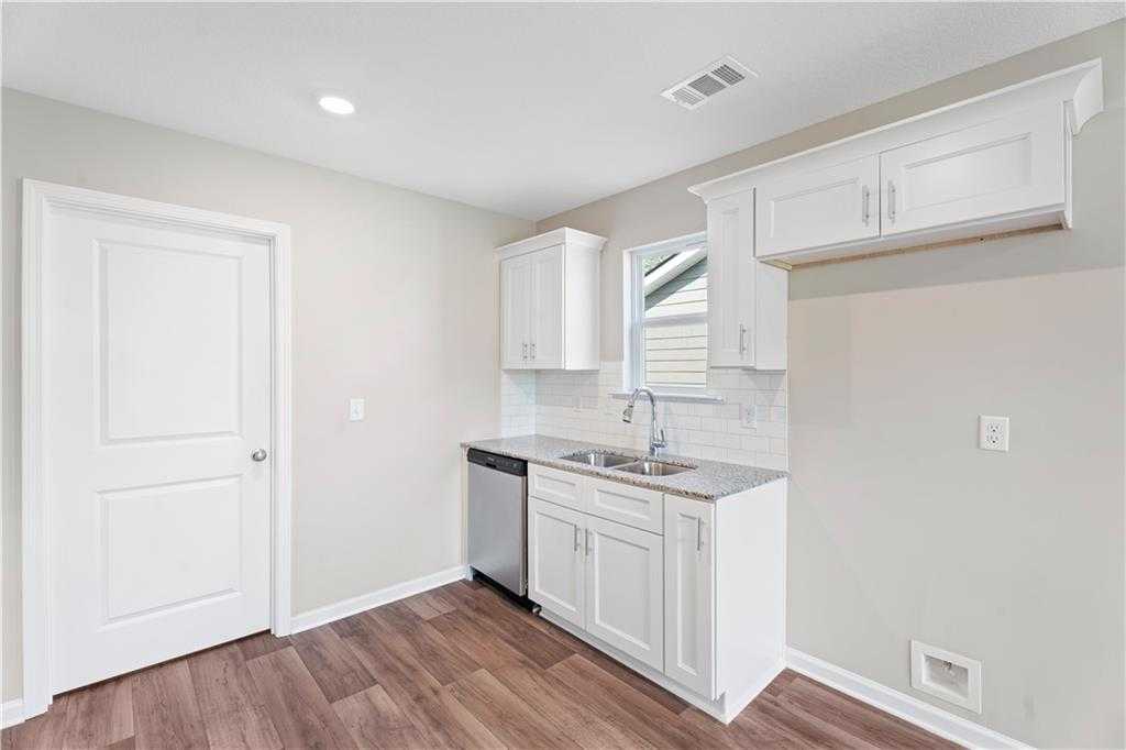 Modern white kitchen with shaker cabinets, quartz counters, stainless sink in The Washington 3BR home, Phenix City, AL