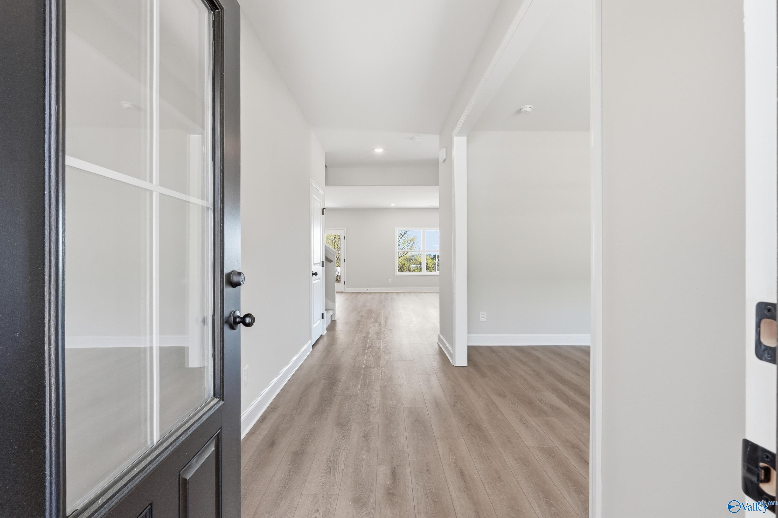 Inviting entry foyer with light hardwood floors, white walls, and open archway in Davidson Homes The Chelsea D, Cullman, Alabama