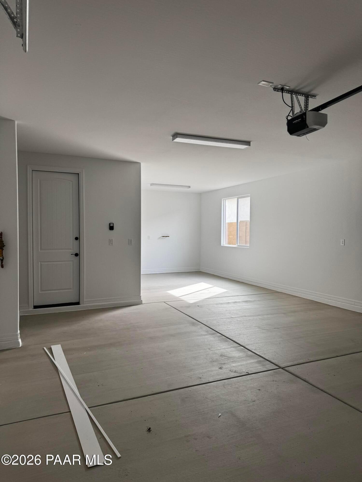 Spacious 3-car garage with concrete floor, white walls, overhead door in The Durango II B by Davidson Homes, Prescott, AZ