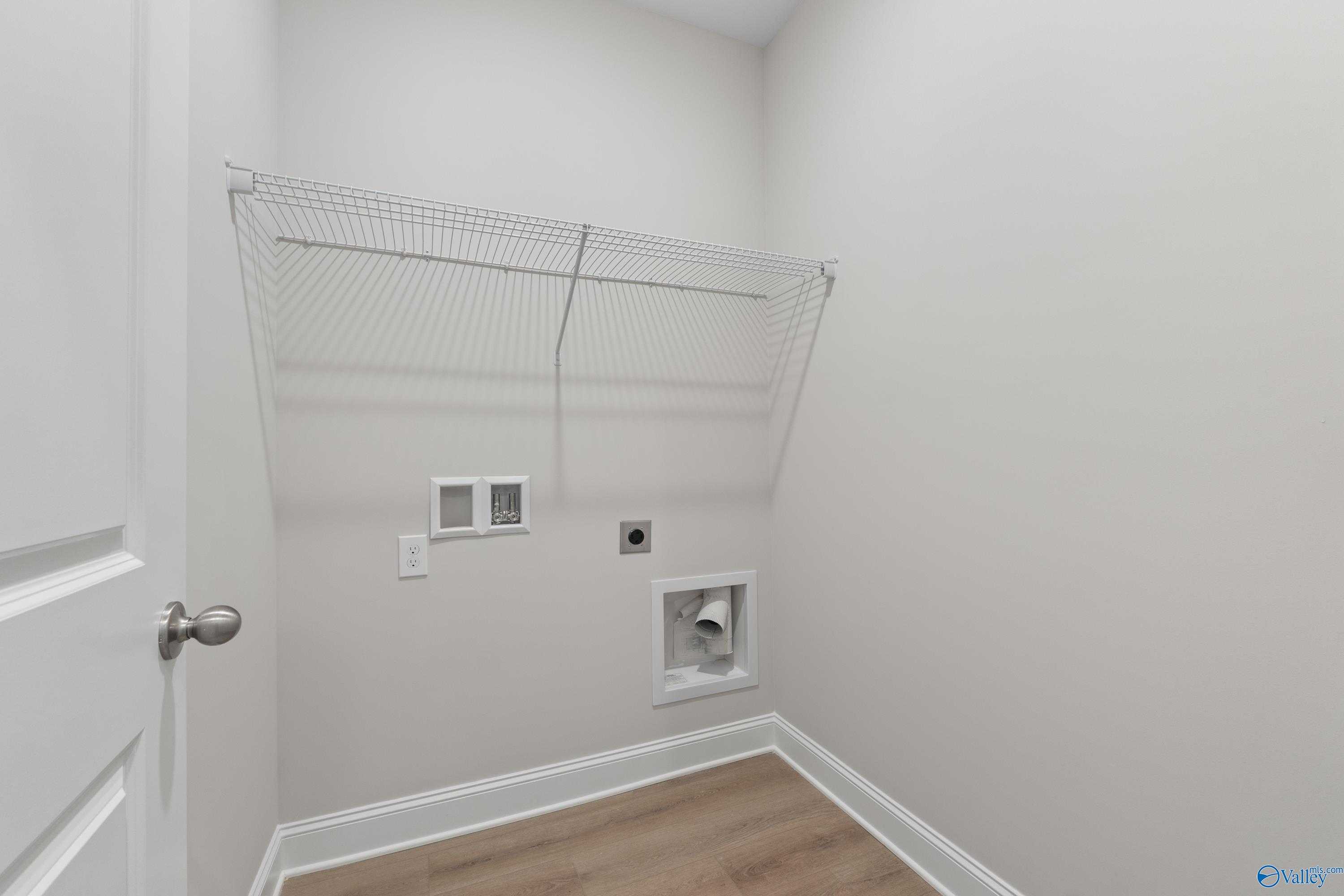 Functional laundry room with wire shelving, washer-dryer hookups in Davidson Homes The Asheville C, Huntsville AL