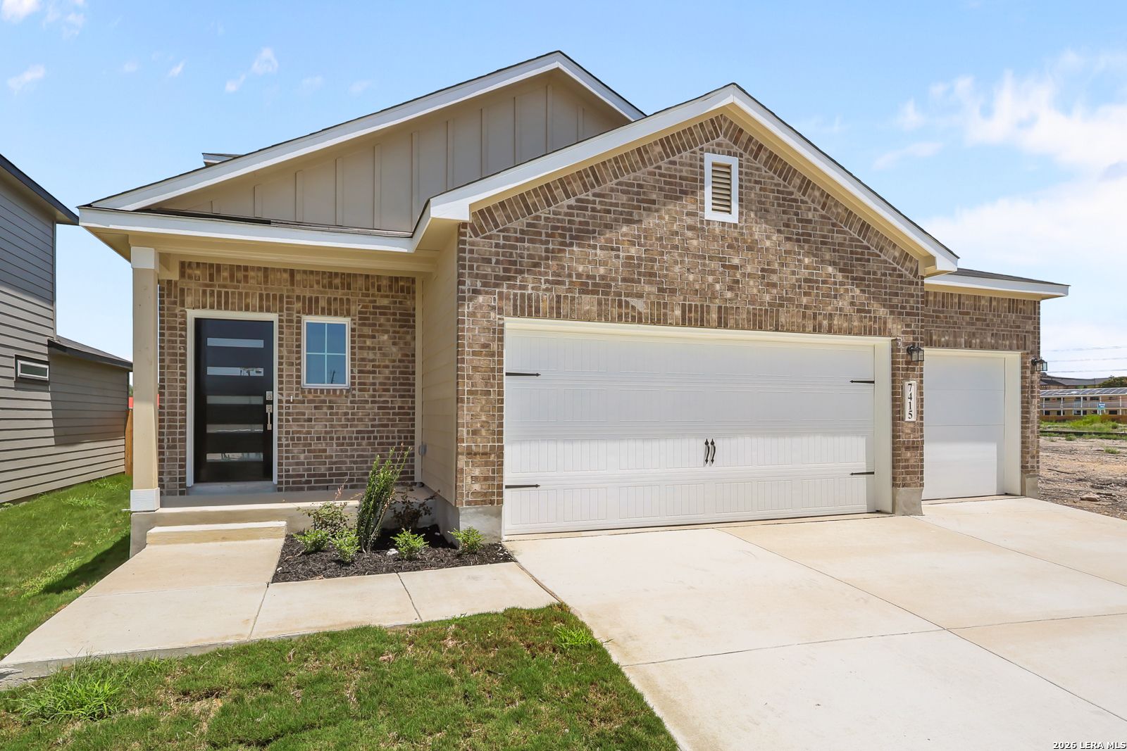 Brick and siding exterior of Davidson Homes The San Marcos F floor plan with a 3-car garage in Rayburn Valley, San Antonio.