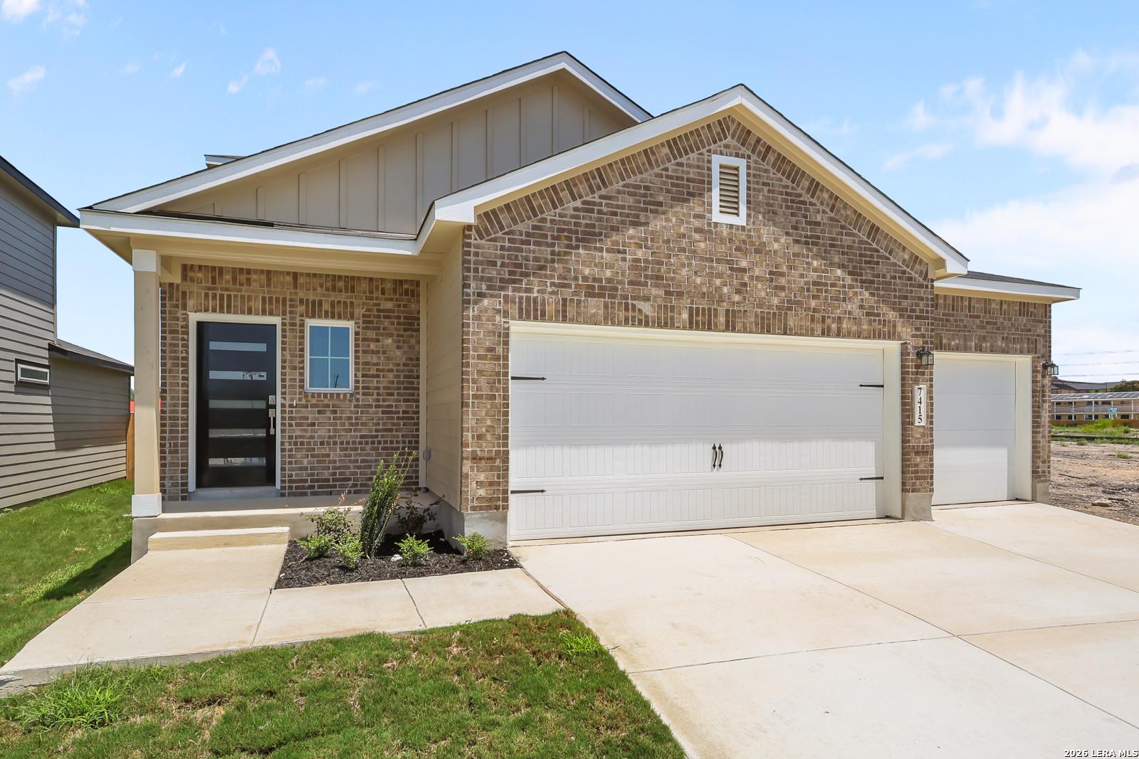 Brick and siding exterior of Davidson Homes The San Marcos F floor plan with a 3-car garage in Rayburn Valley, San Antonio.