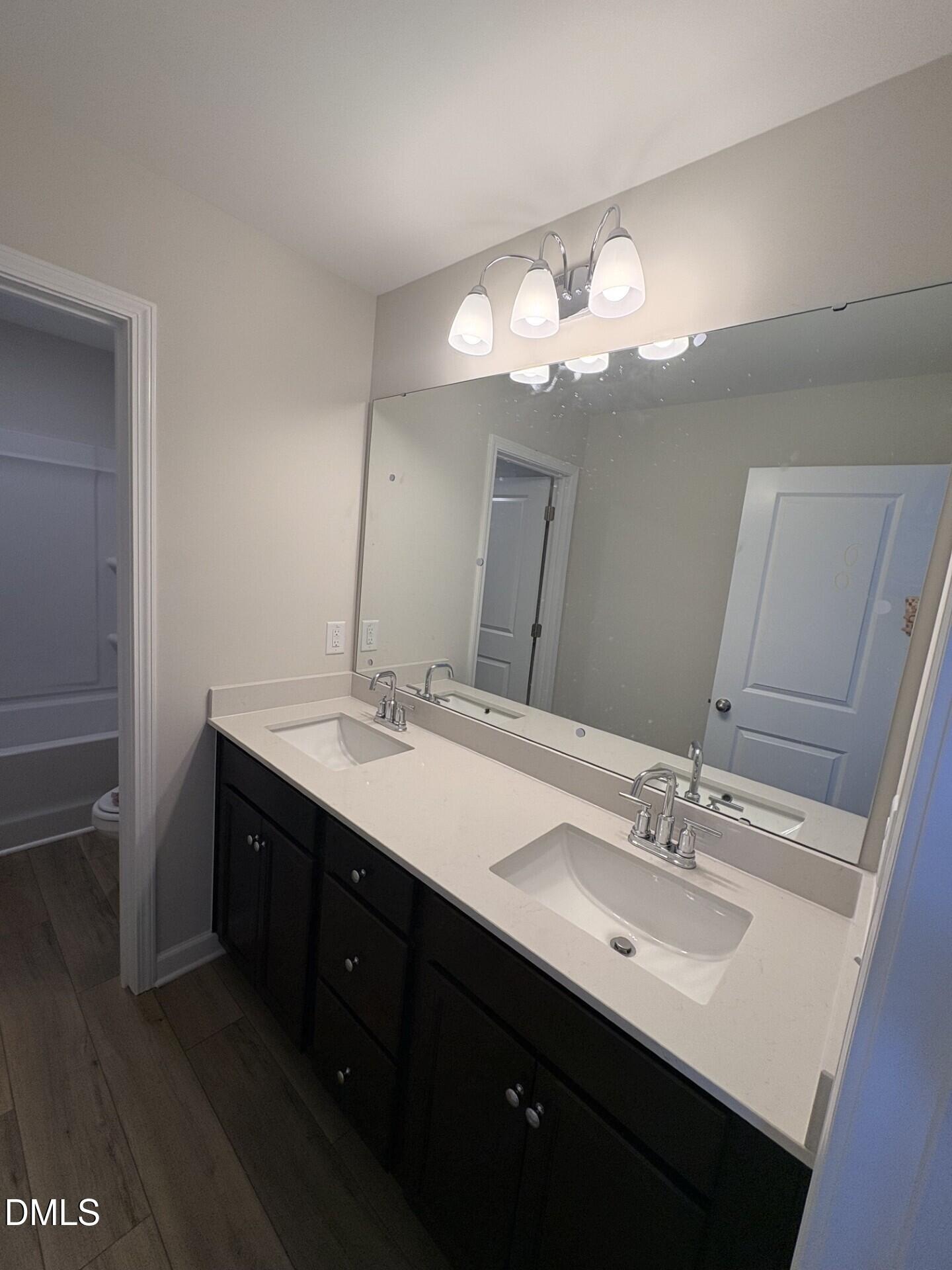 Modern double vanity with dark cabinets and quartz countertops in The Ash C home at Woodland Crossing, Zebulon, NC.