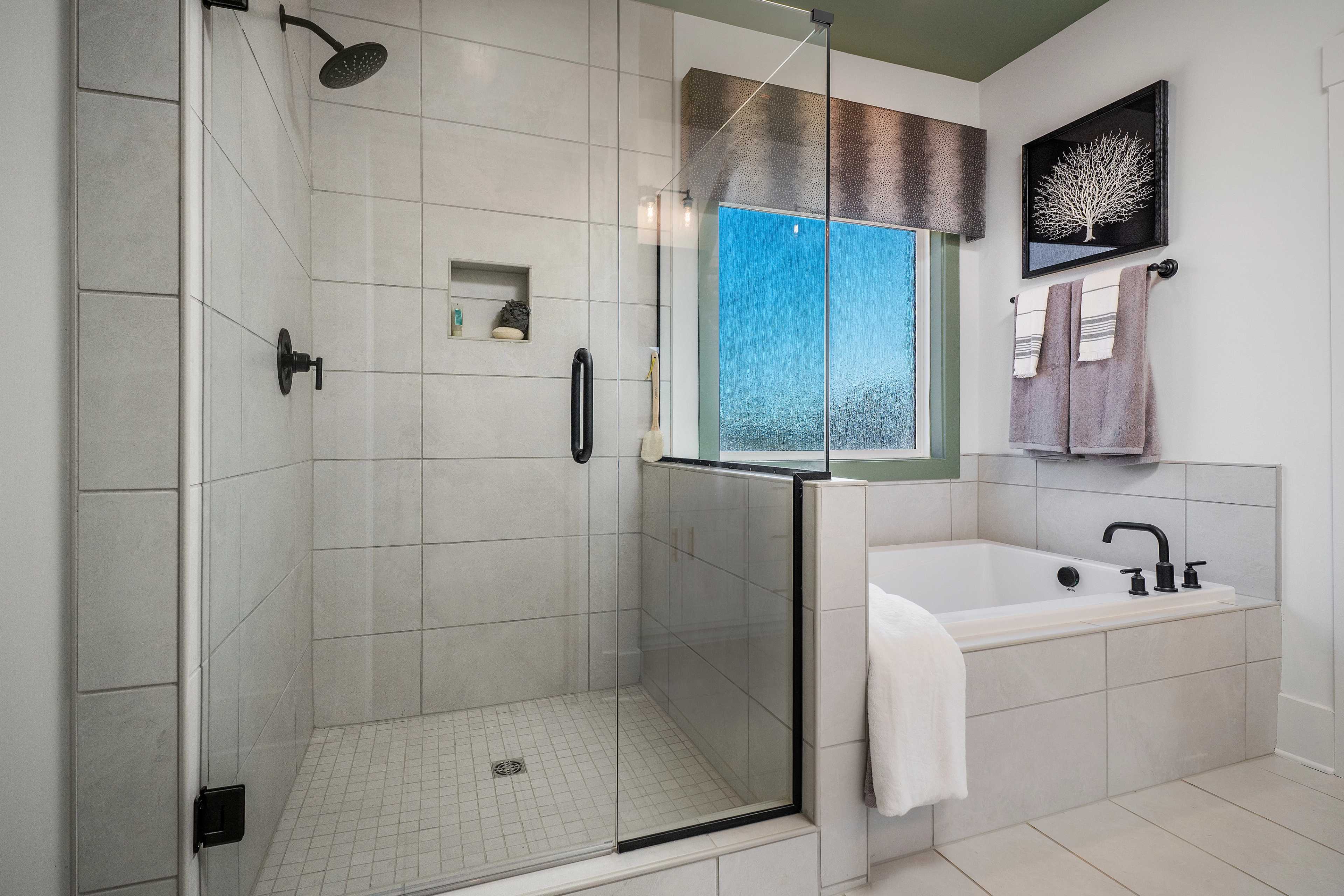 Luxury master bathroom at Barnett's Crossing in Madison, Alabama with tiled walk-in shower and freestanding tub