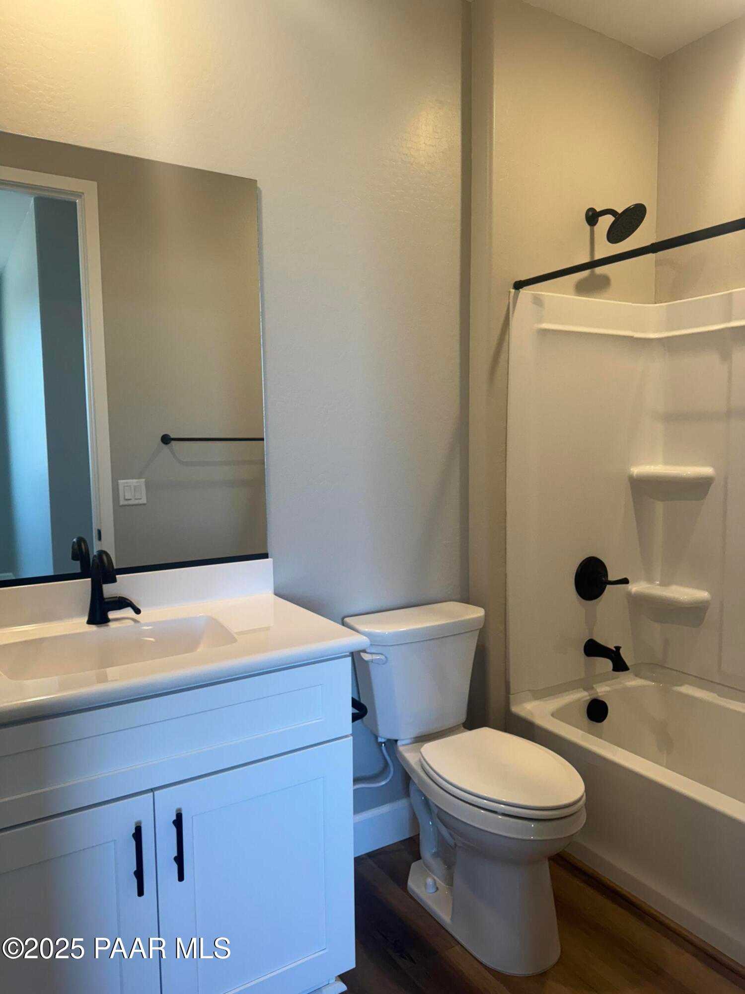 Modern bathroom featuring white vanity, soaking tub, glass shower, and black fixtures in Evermore Homes The Summit B, Prescott Valley, AZ