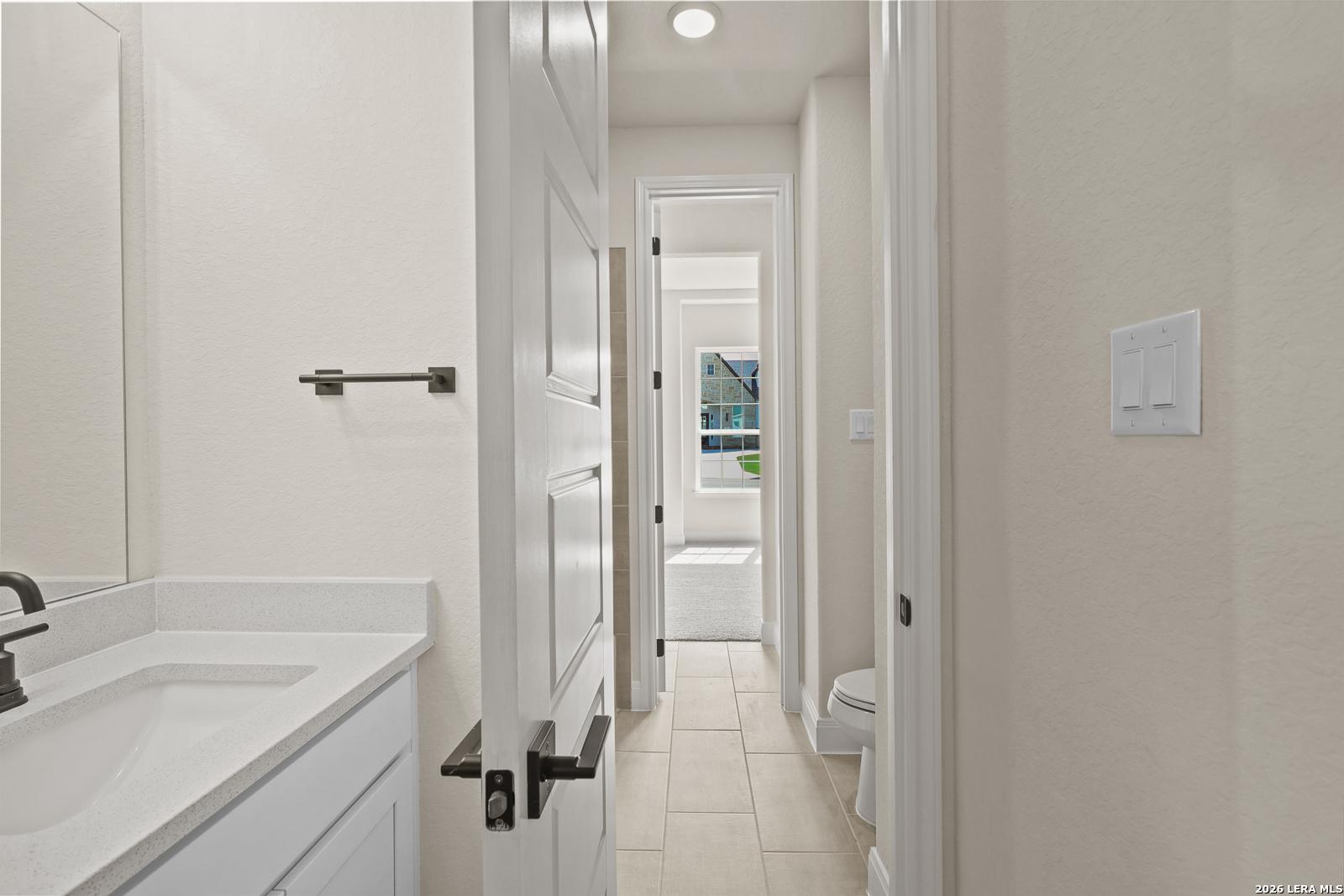 Modern bathroom with white vanity and tile flooring in The Summerlin B floor plan by Davidson Homes, Potranco Oaks.