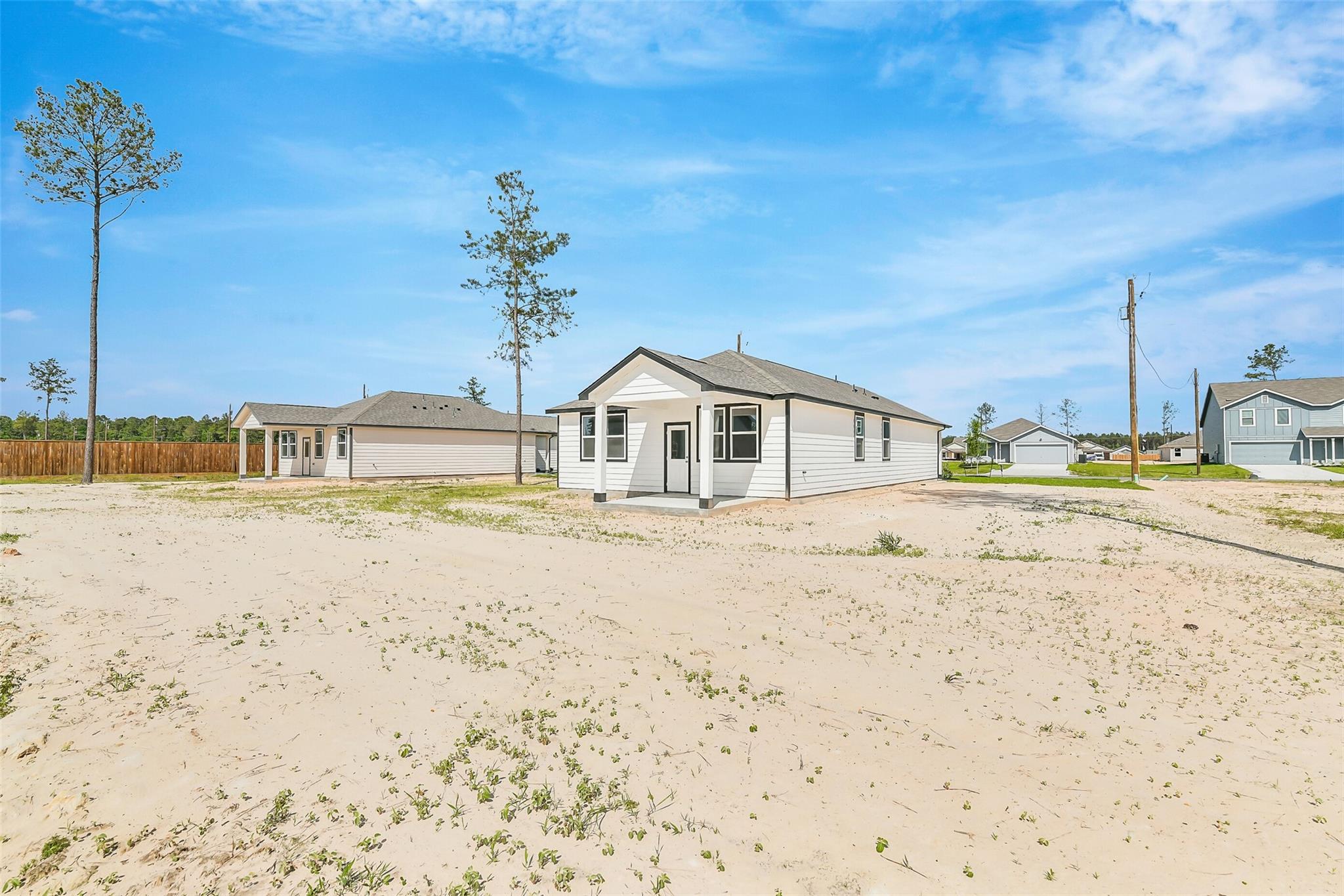 Single-story white home with columned front porch and gabled roof in Spring Branch Crossing, Conroe, Texas - Davidson Homes The Frio G