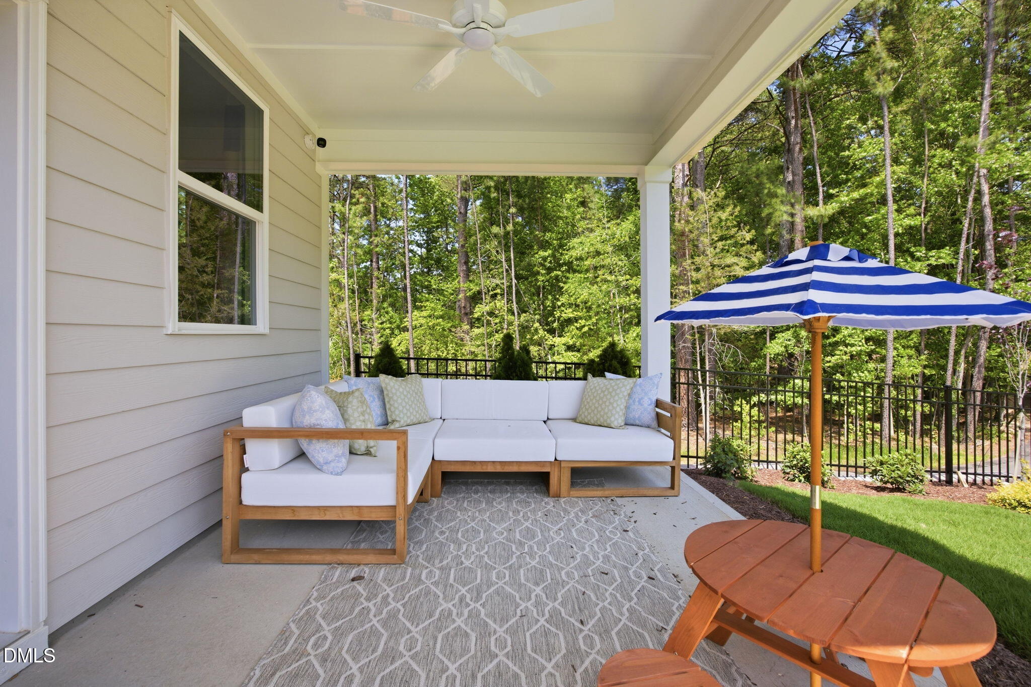 Covered patio with outdoor sectional and striped umbrella at The Ashport M in Wendell Ridge, Wendell, North Carolina.